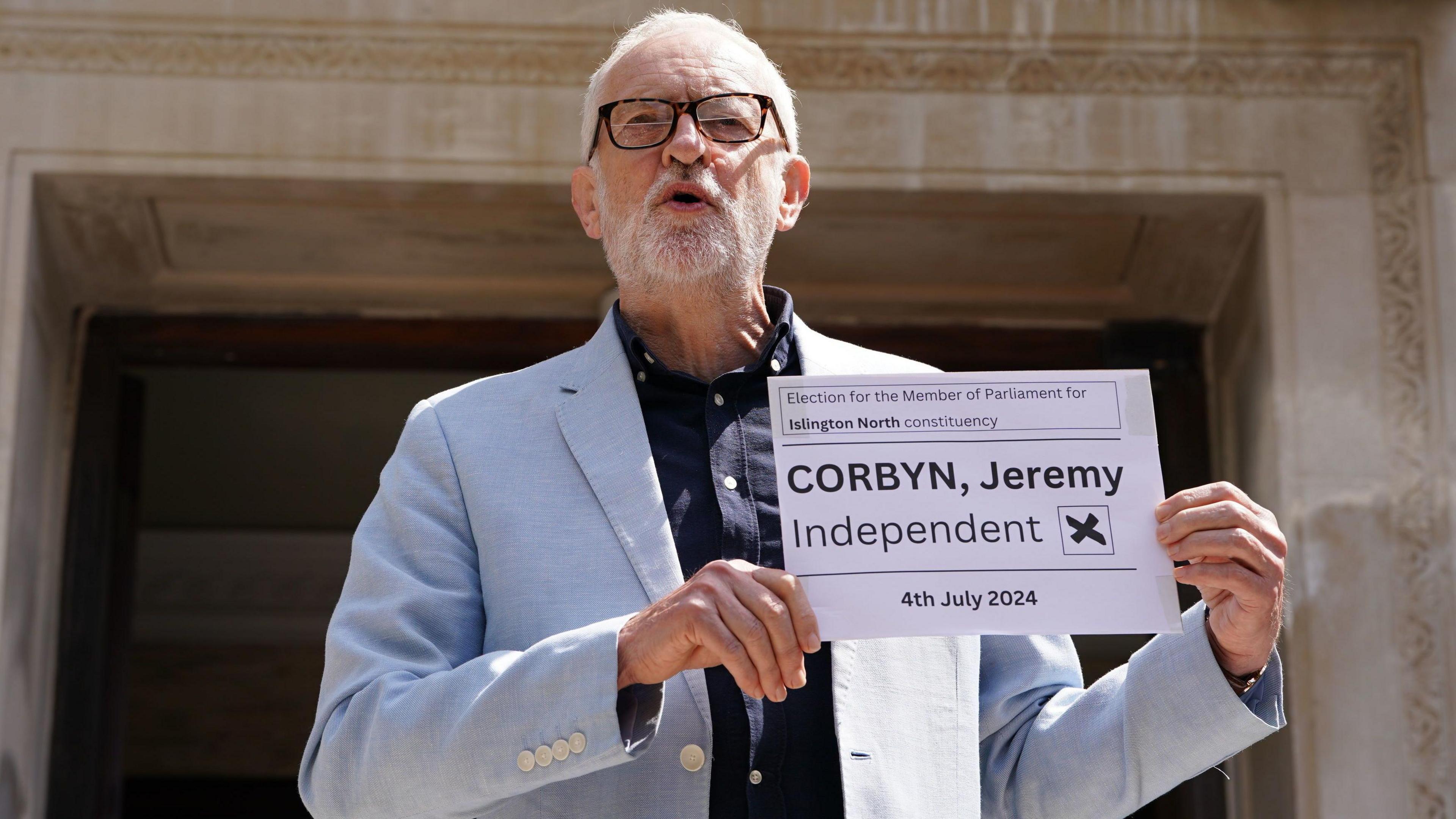 Jeremy Corbyn holding placard with word 'independent'