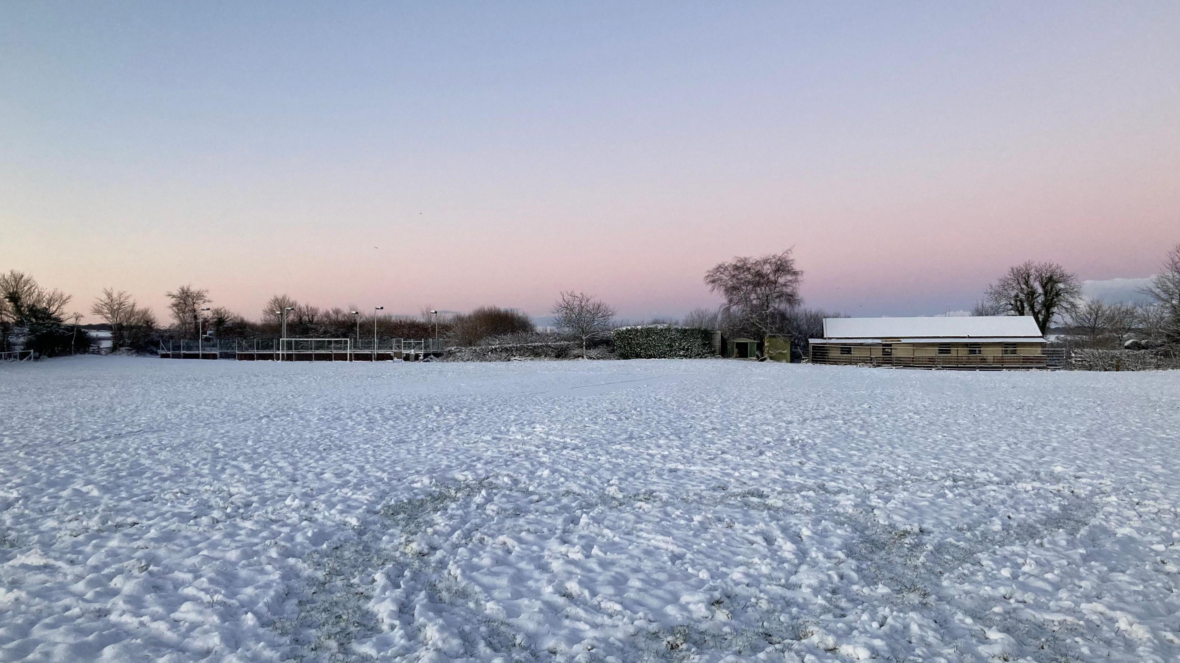 A field covered in snow at sunrise