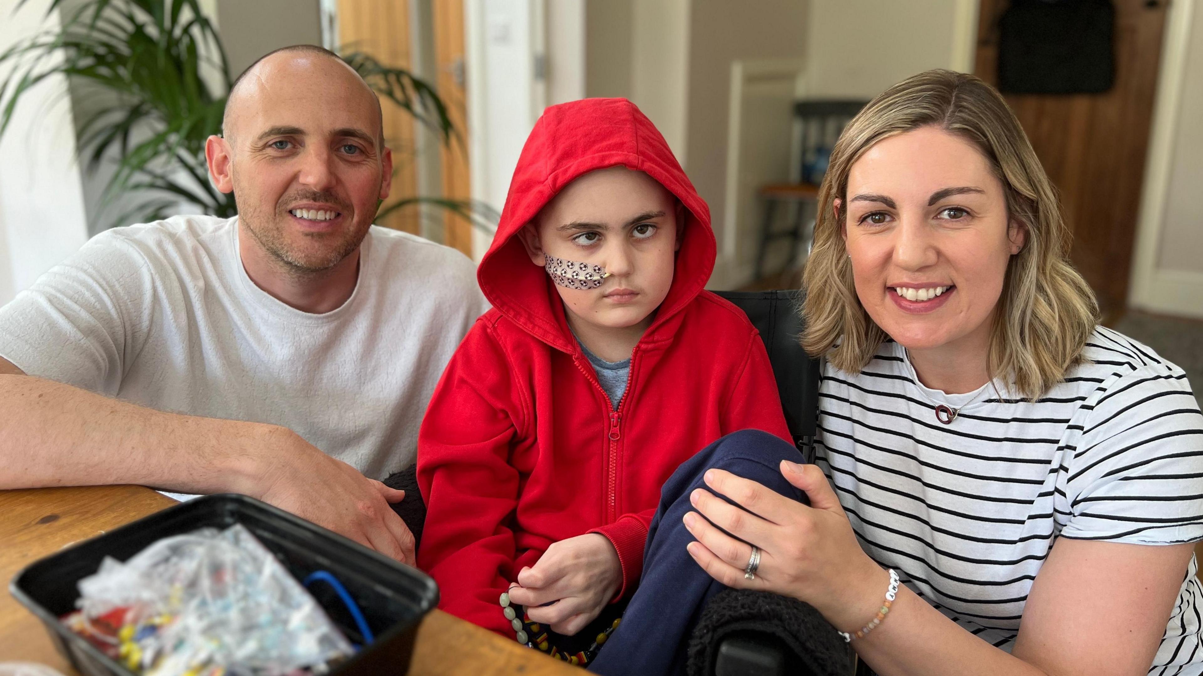 James with mum and dad at home