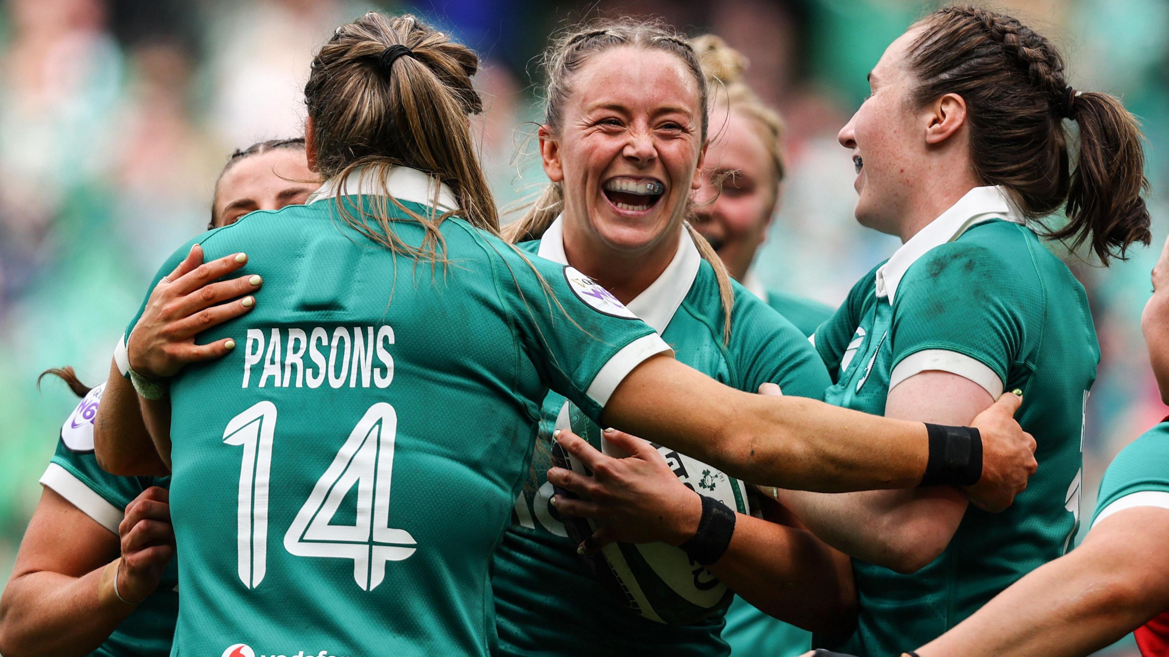 Stacey Flood celebrates with Eve Higgins and Beibhinn Parsons after scoring a try 