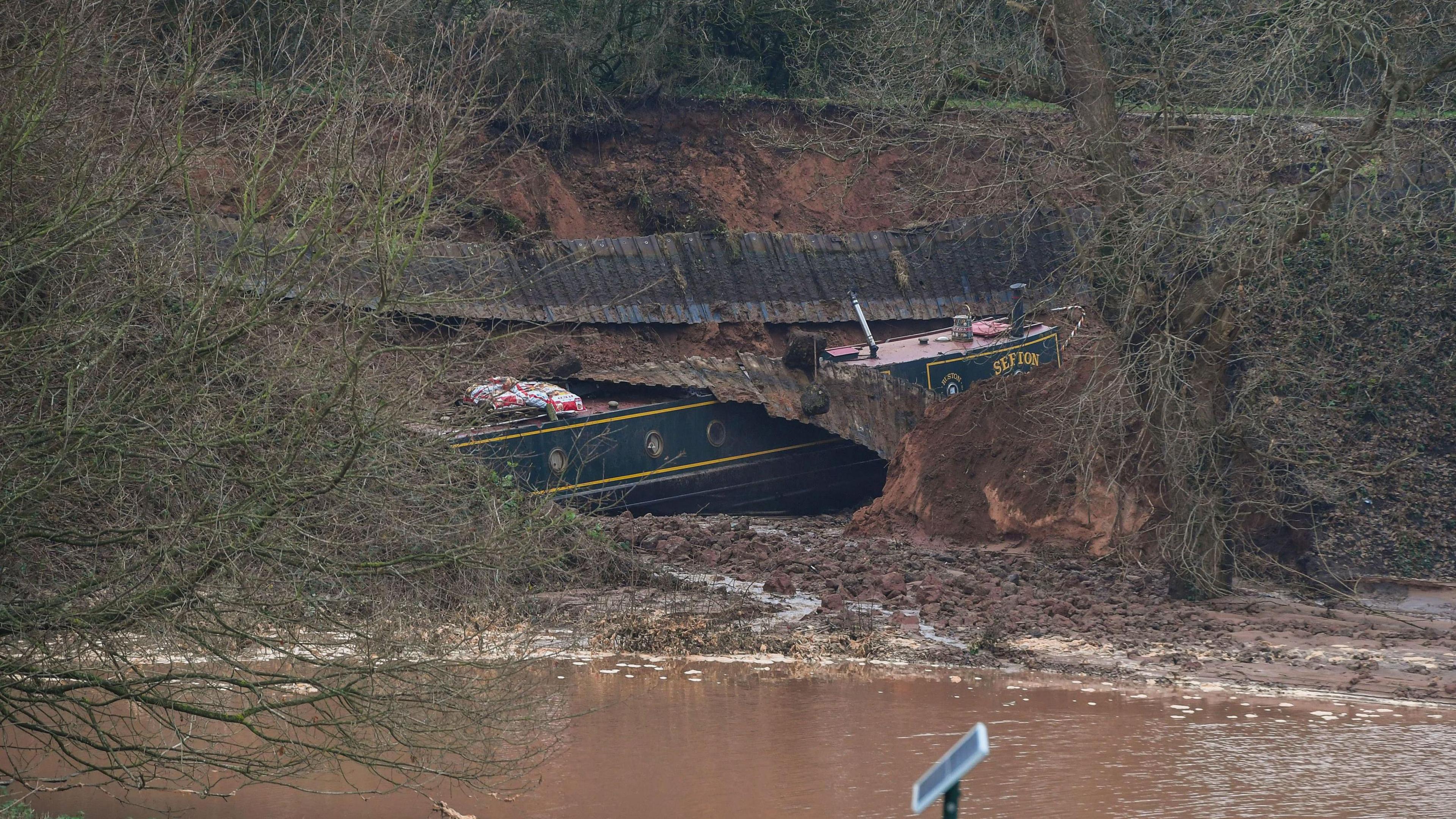 A canal boat in a large hole