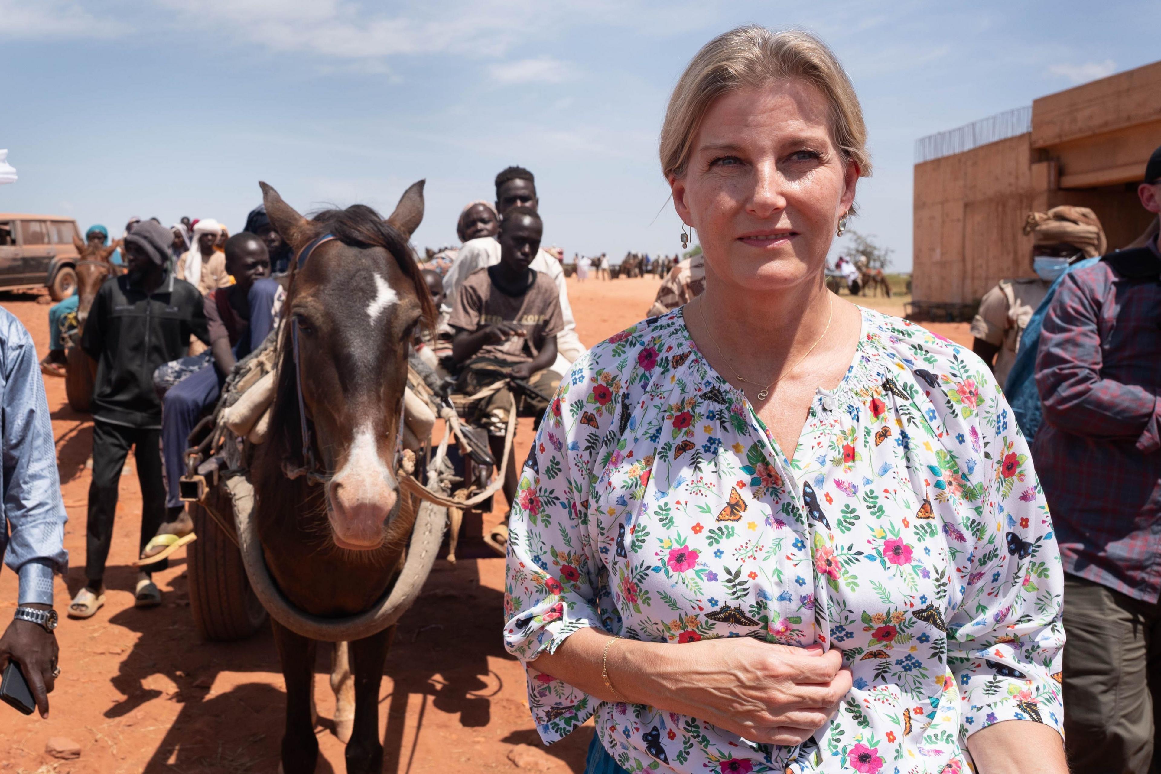 Sophie, Duchesss of Edinburgh, in Chad, with a horse and cart in the background