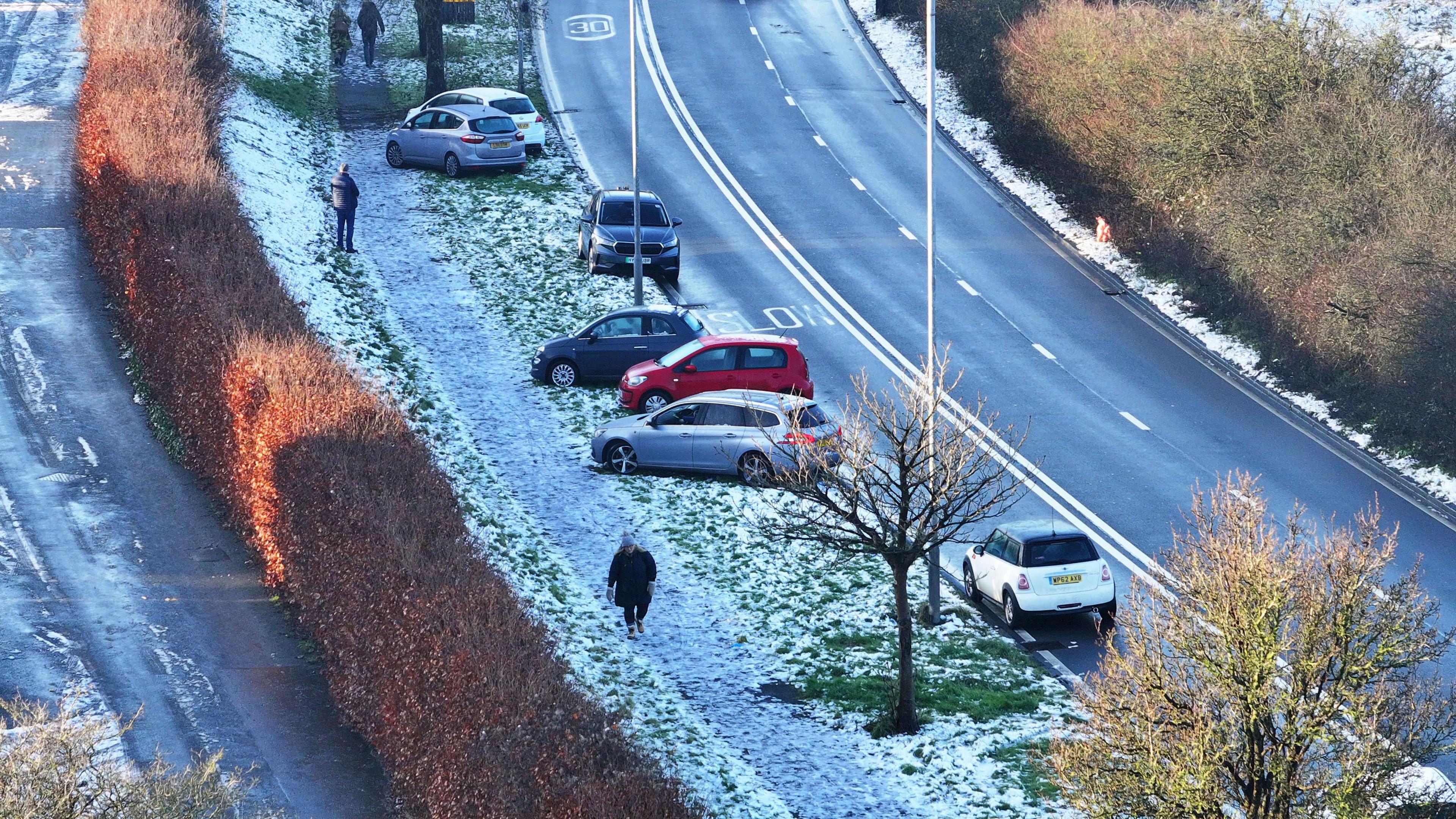 Abandoned cars are visible on roads dusted with snow and ice. 