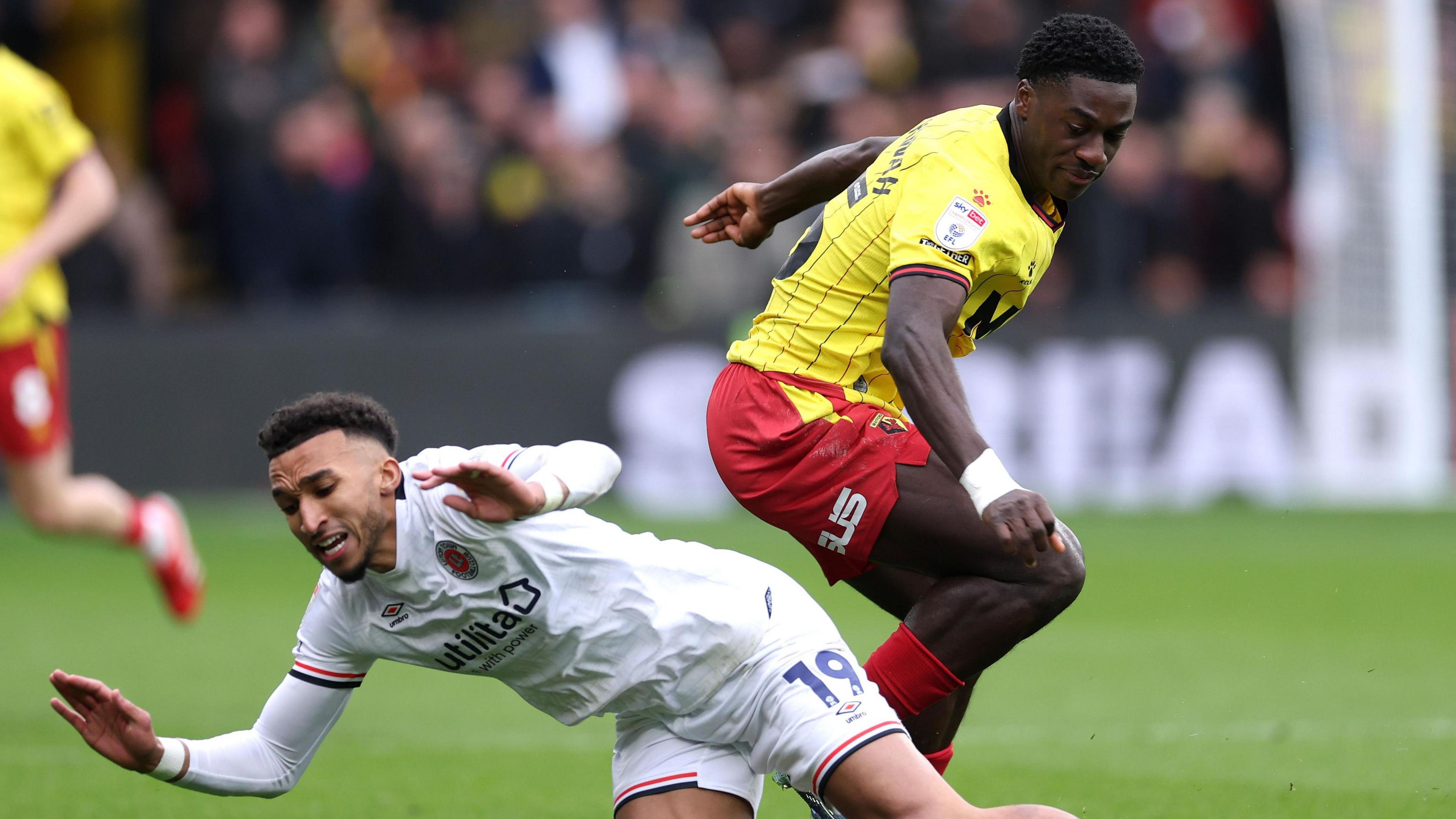 Luton's Jacob Brown goes down in a challenge with James Abankwah of Watford