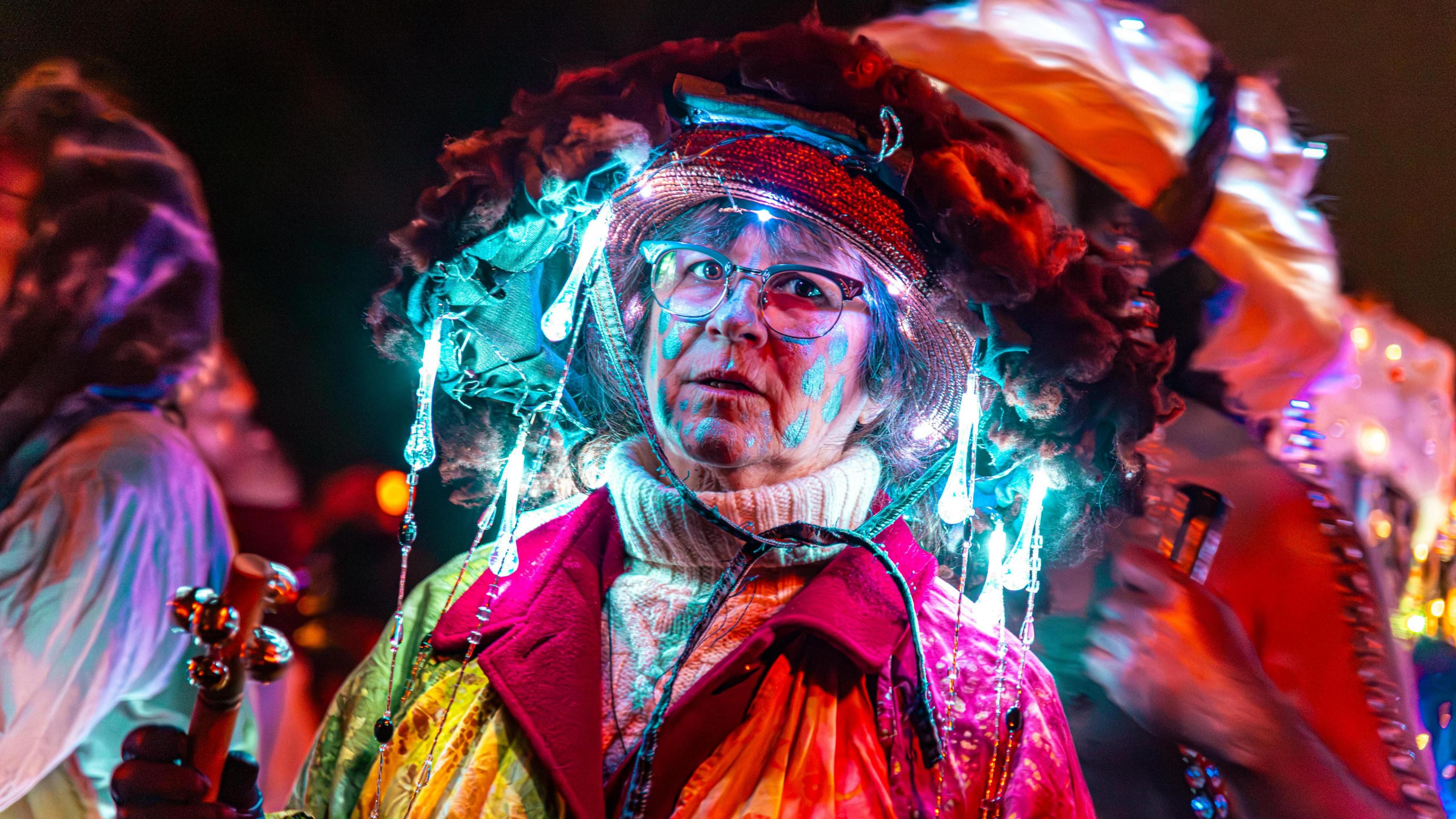 A lady wearing a colourful and light emitting hat