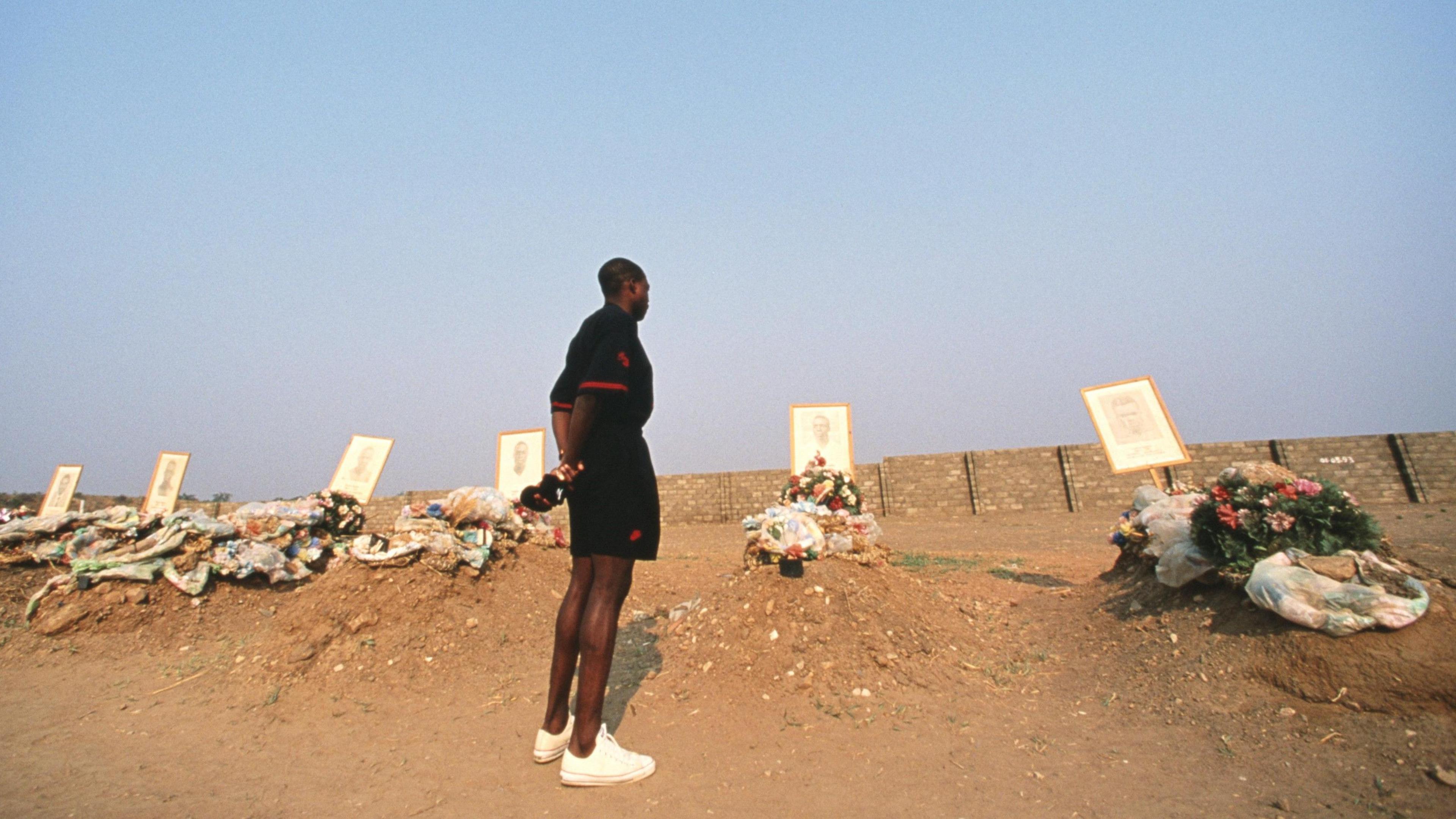 Kalusha Bwalya stands in front of a set of freshly dug graves in Hero's Acre