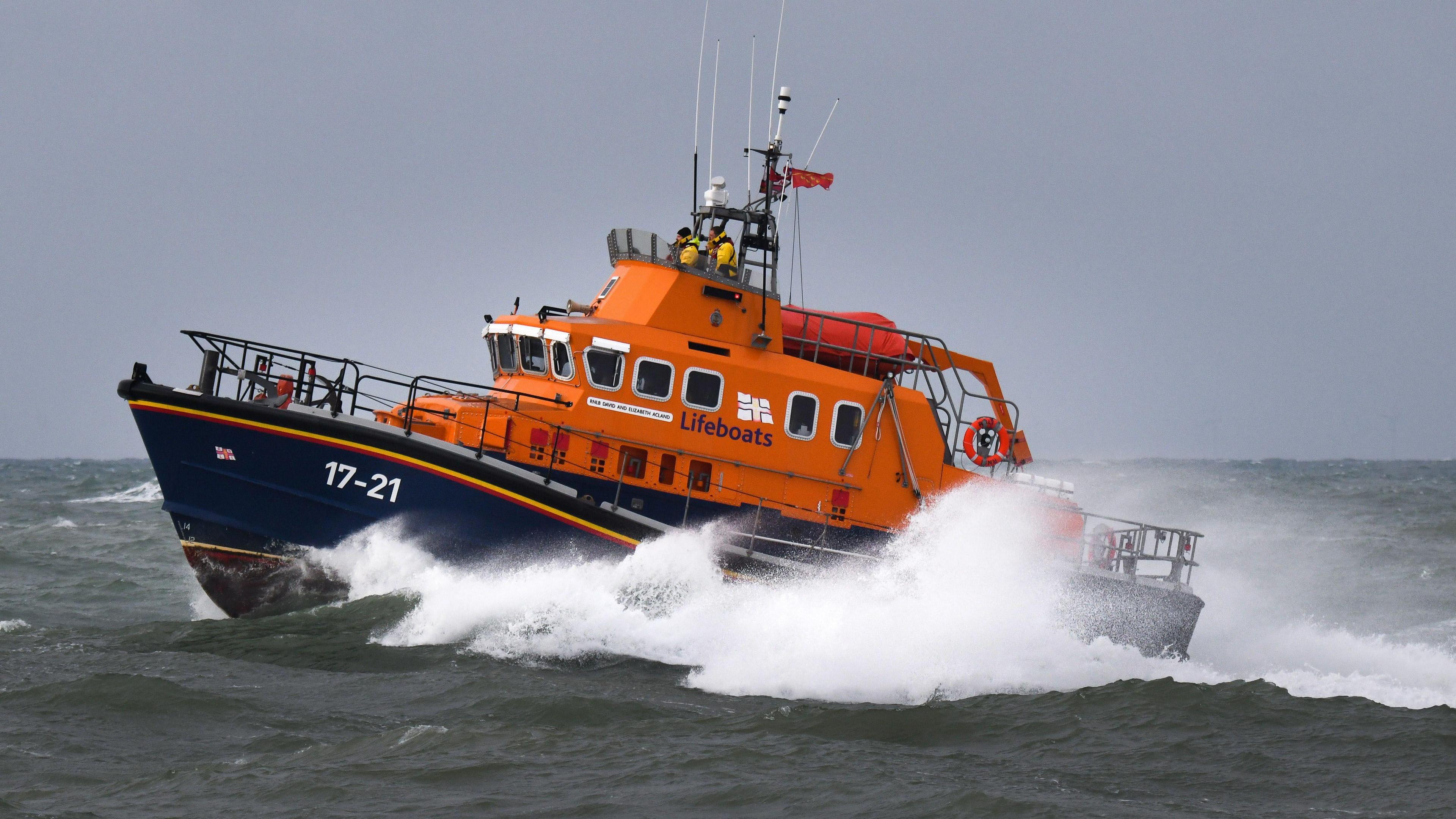 An orange lifeboat in the sea.