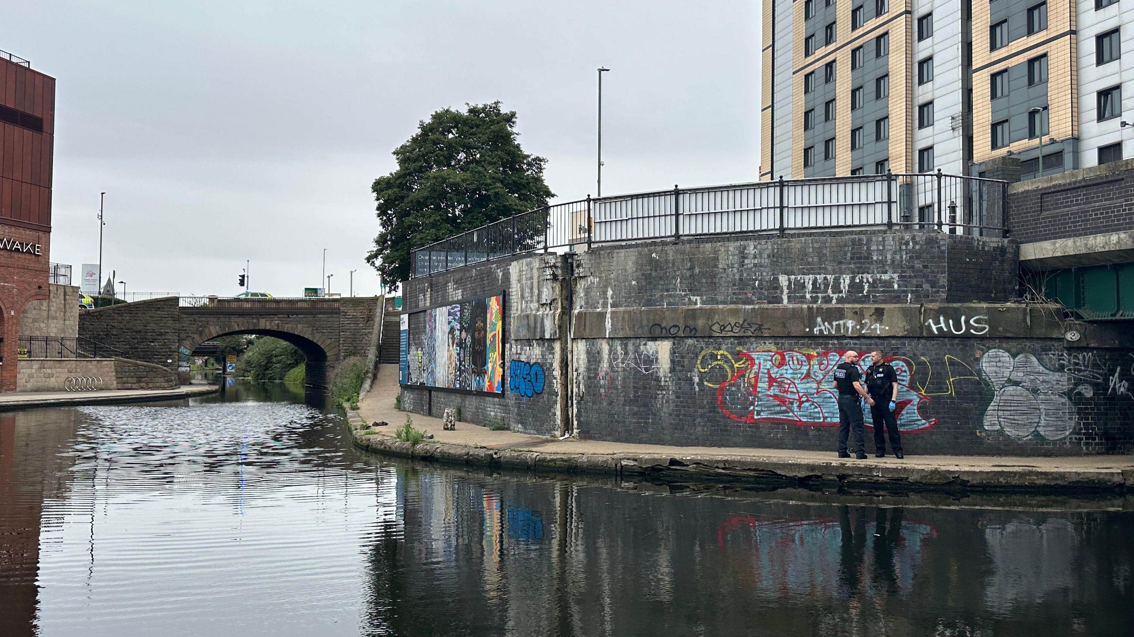 Two officers stood on a canal path near a turning basin