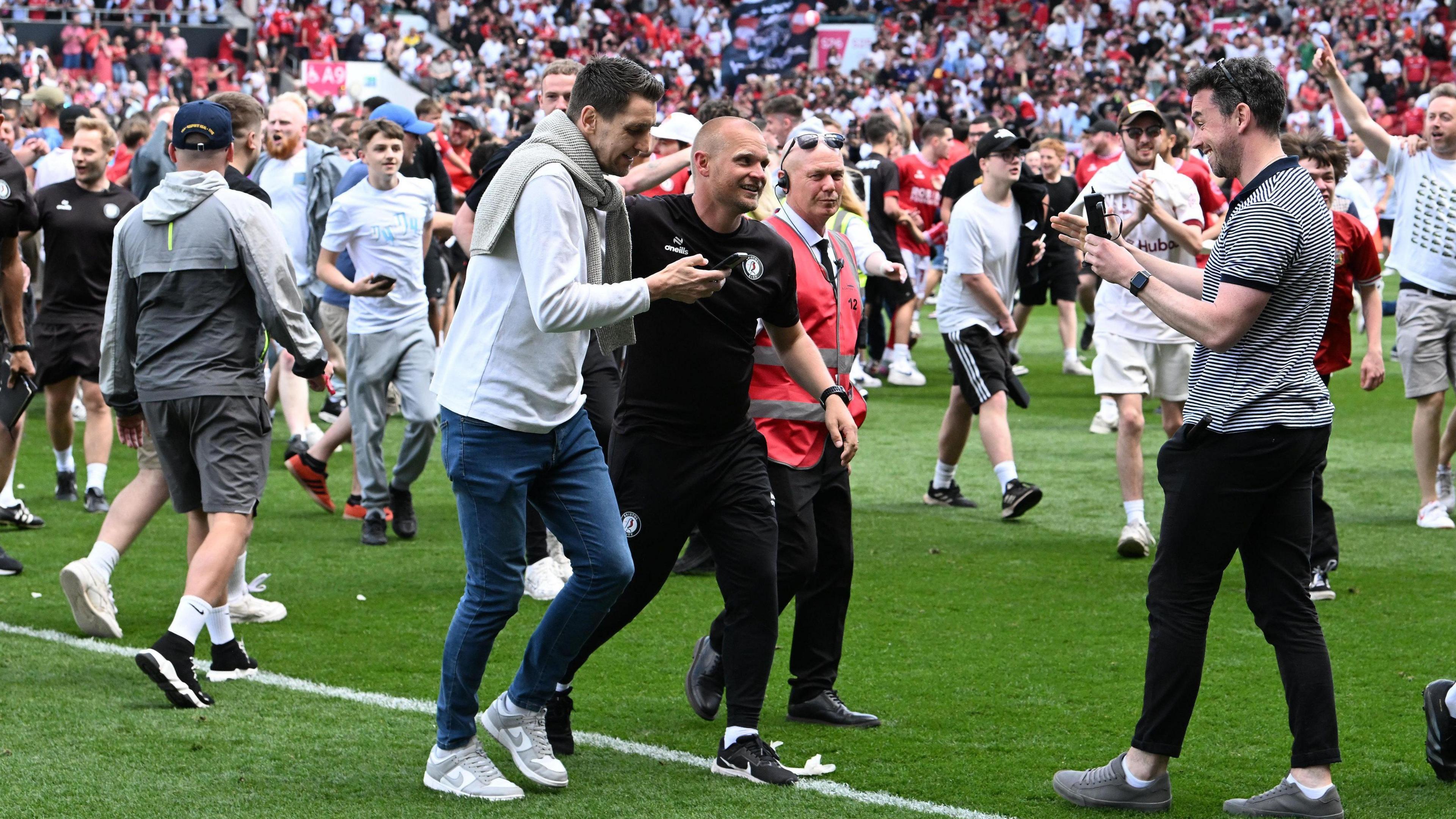 Liam Manning is mobbed by Bristol City fans on the Ashton Gate turf