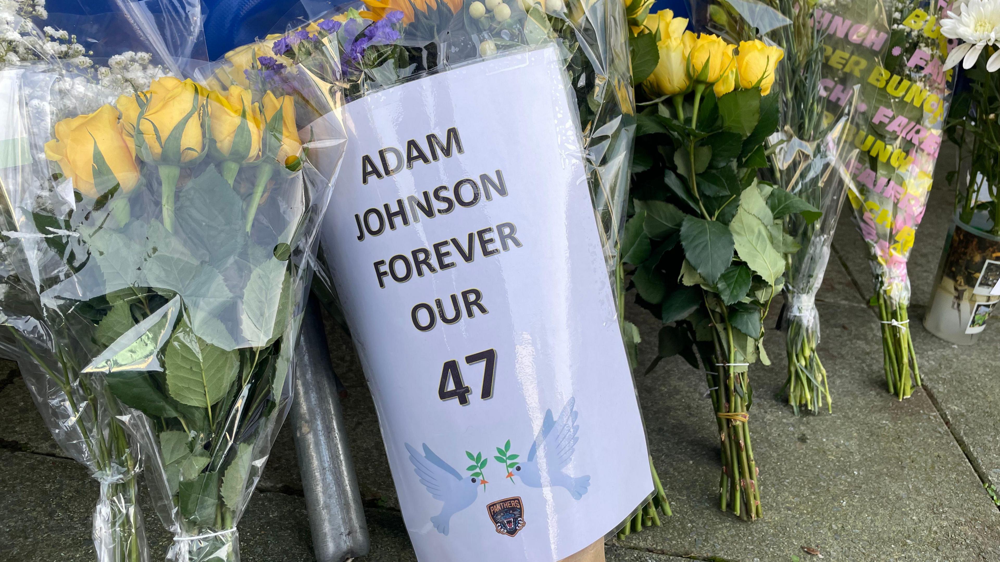 A bouquet of flowers with a message reading "forever our 47" on a piece of paper