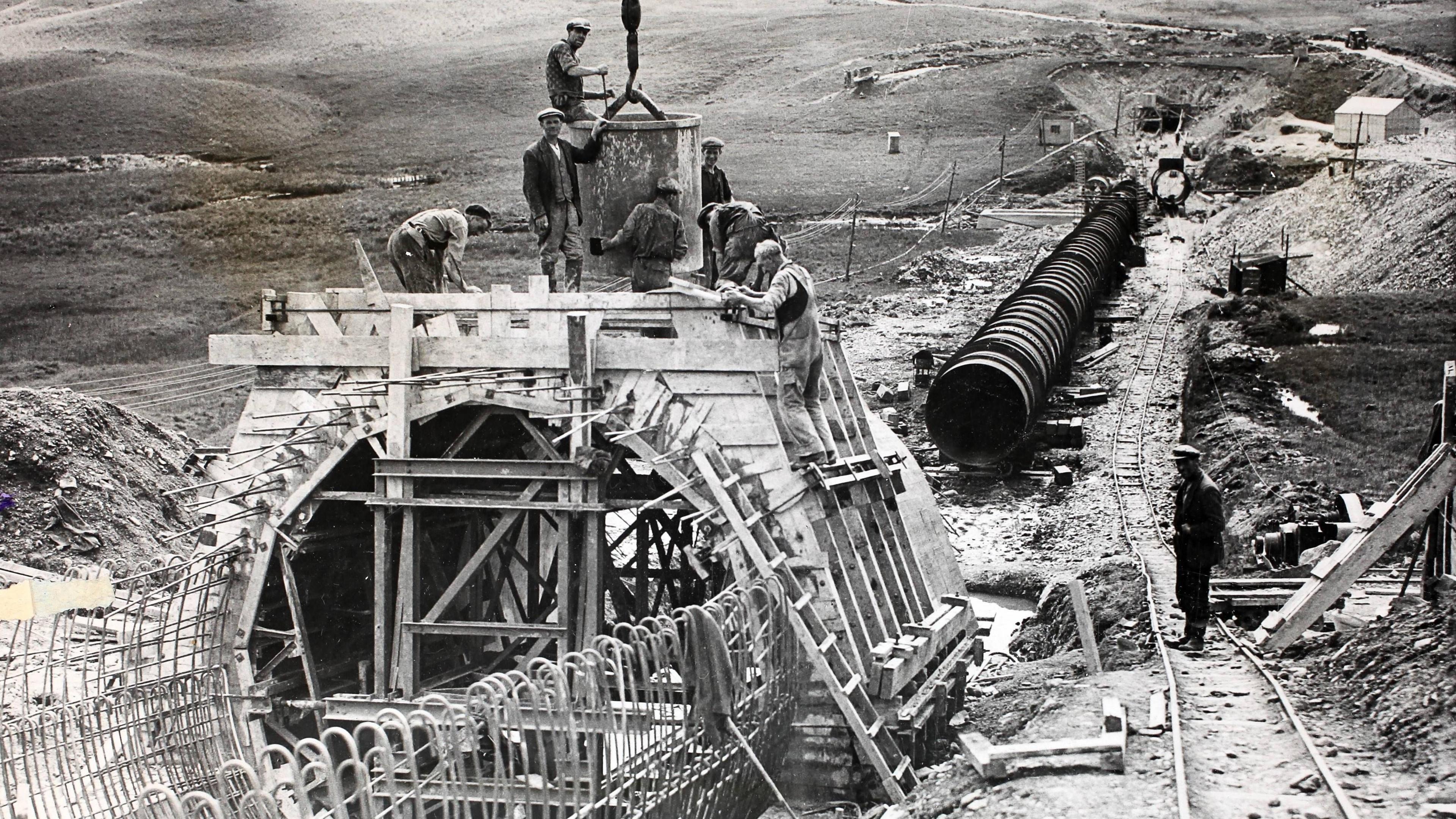 A black and white picture of men working on a massive pipeline as part of the Galloway hydro scheme