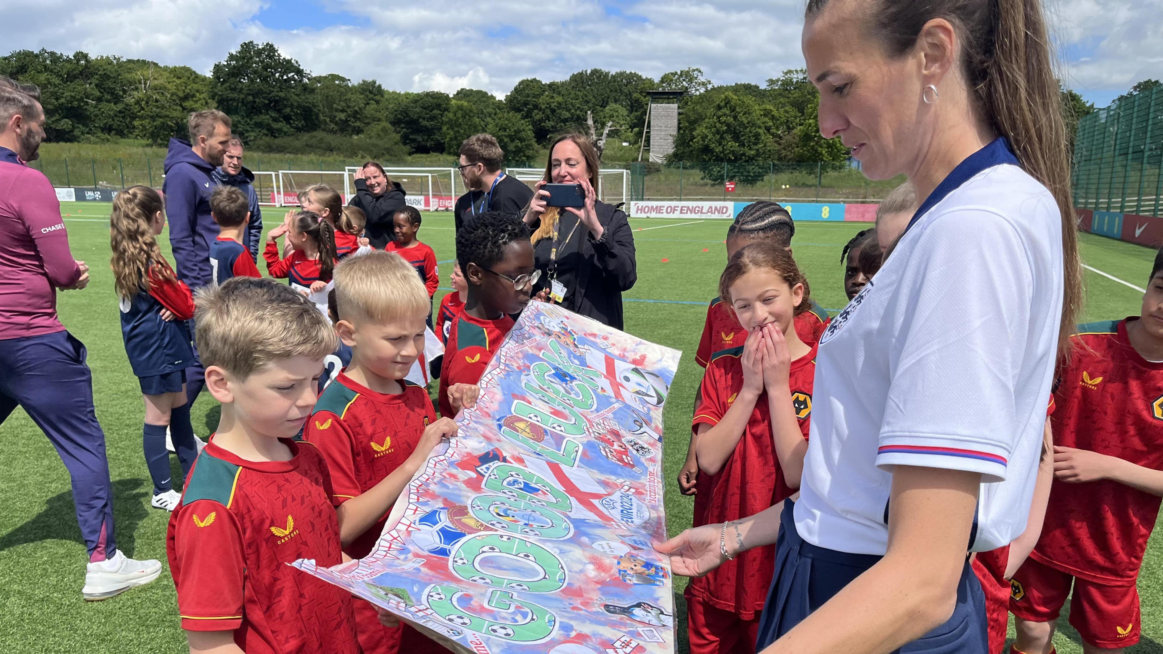 Children holding the banner with former footballer Jill Scott