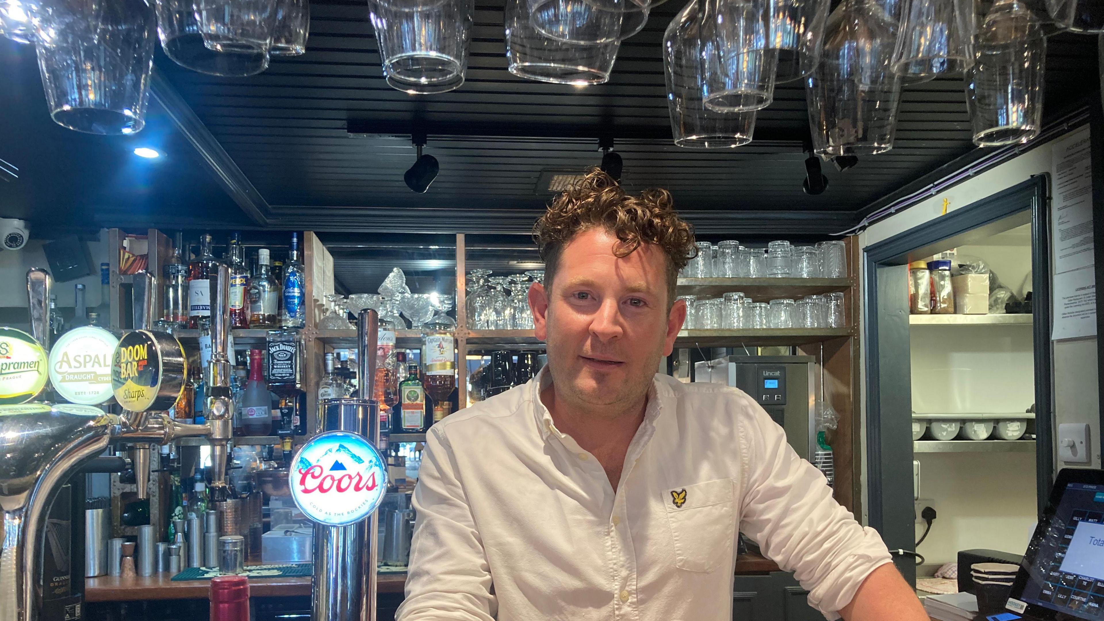 Business owner Matthew Ronowitz behind the bar in his restaurant in Tenby. 