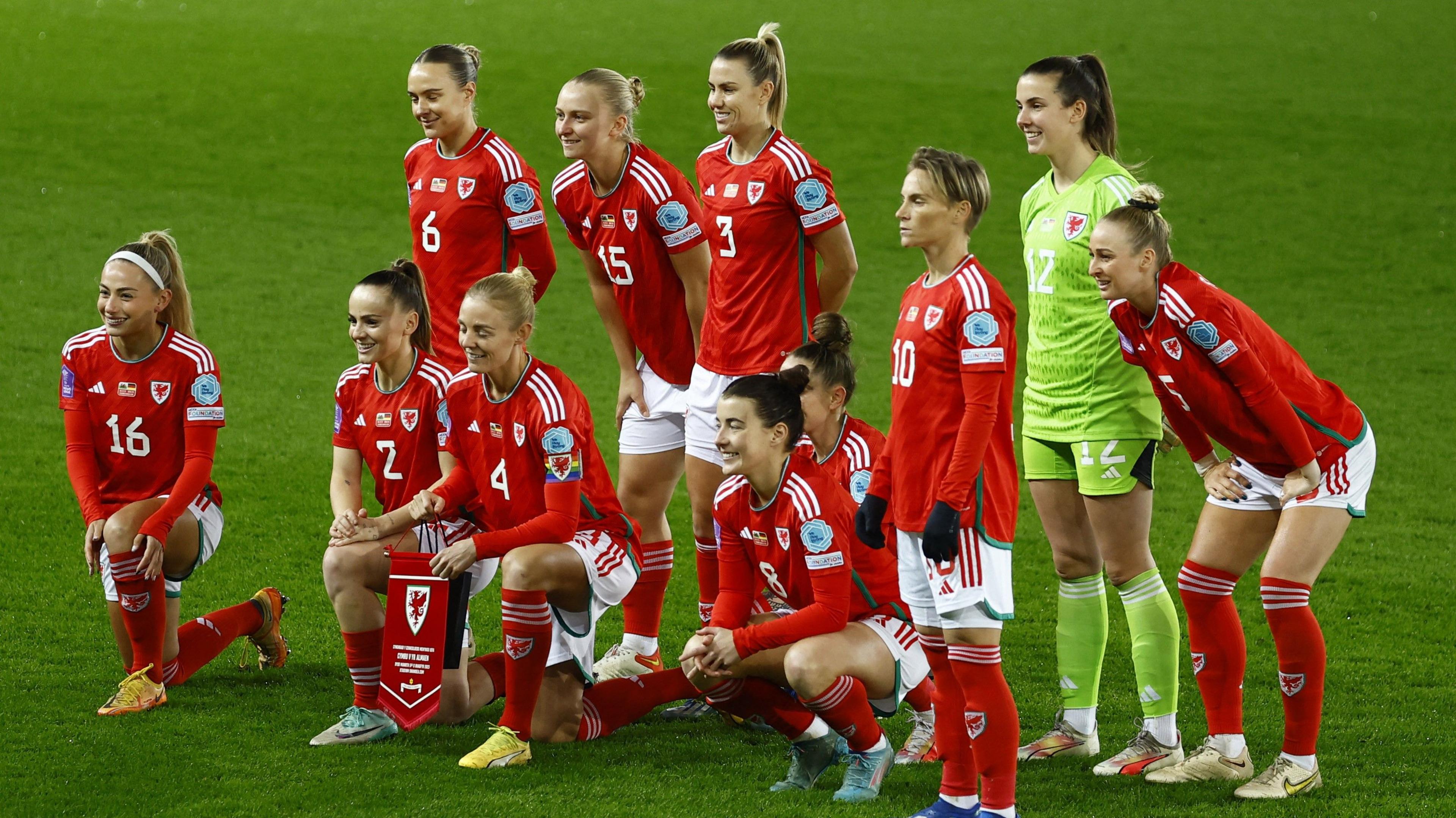 Welsh football team posing for a photo on the football pitch 