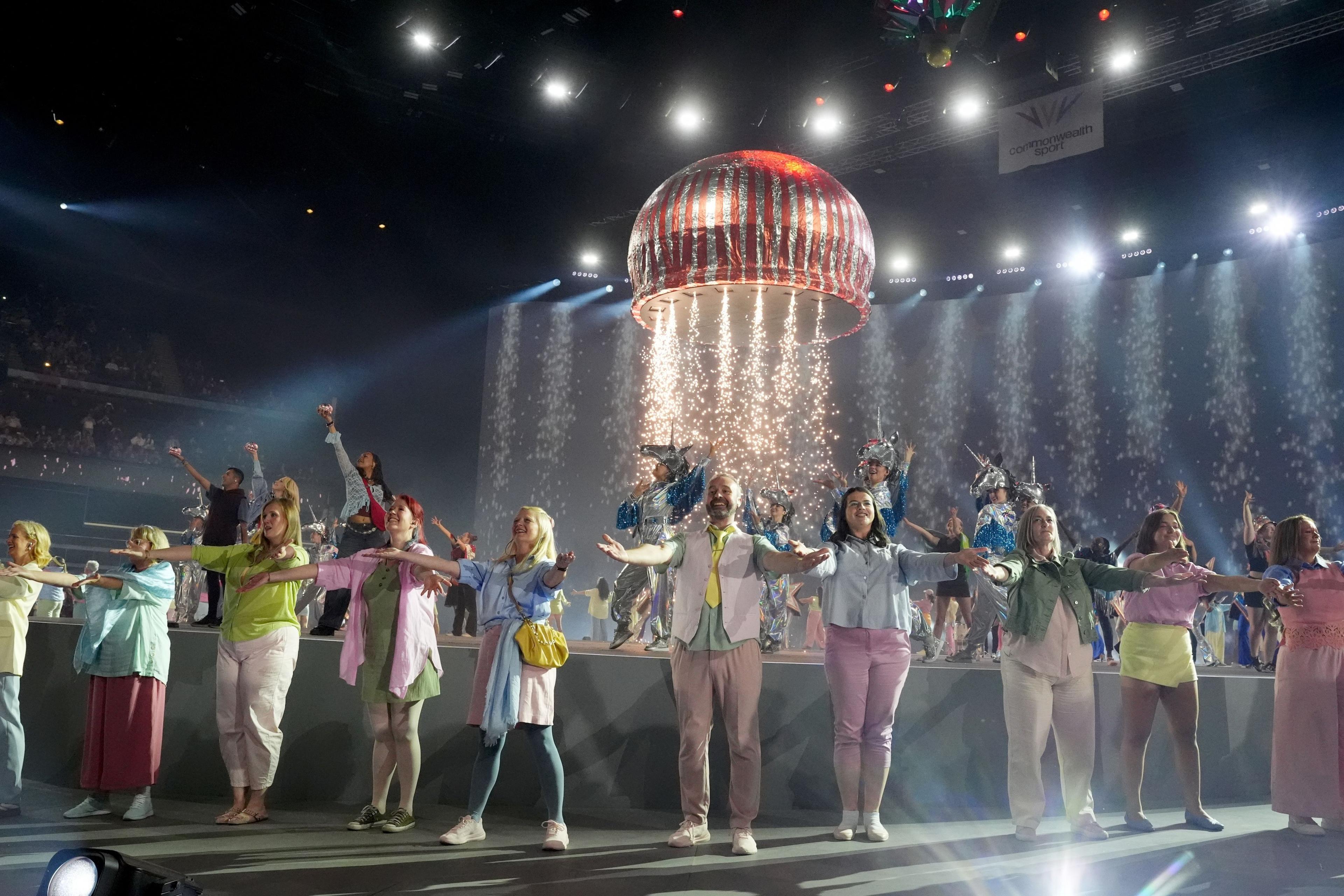 Dancers performing as a giant Teacake with pyrotechnics hands form the celling at the conclusion of the opening ceremony for the 2026 Commonwealth Games in Glasgow.