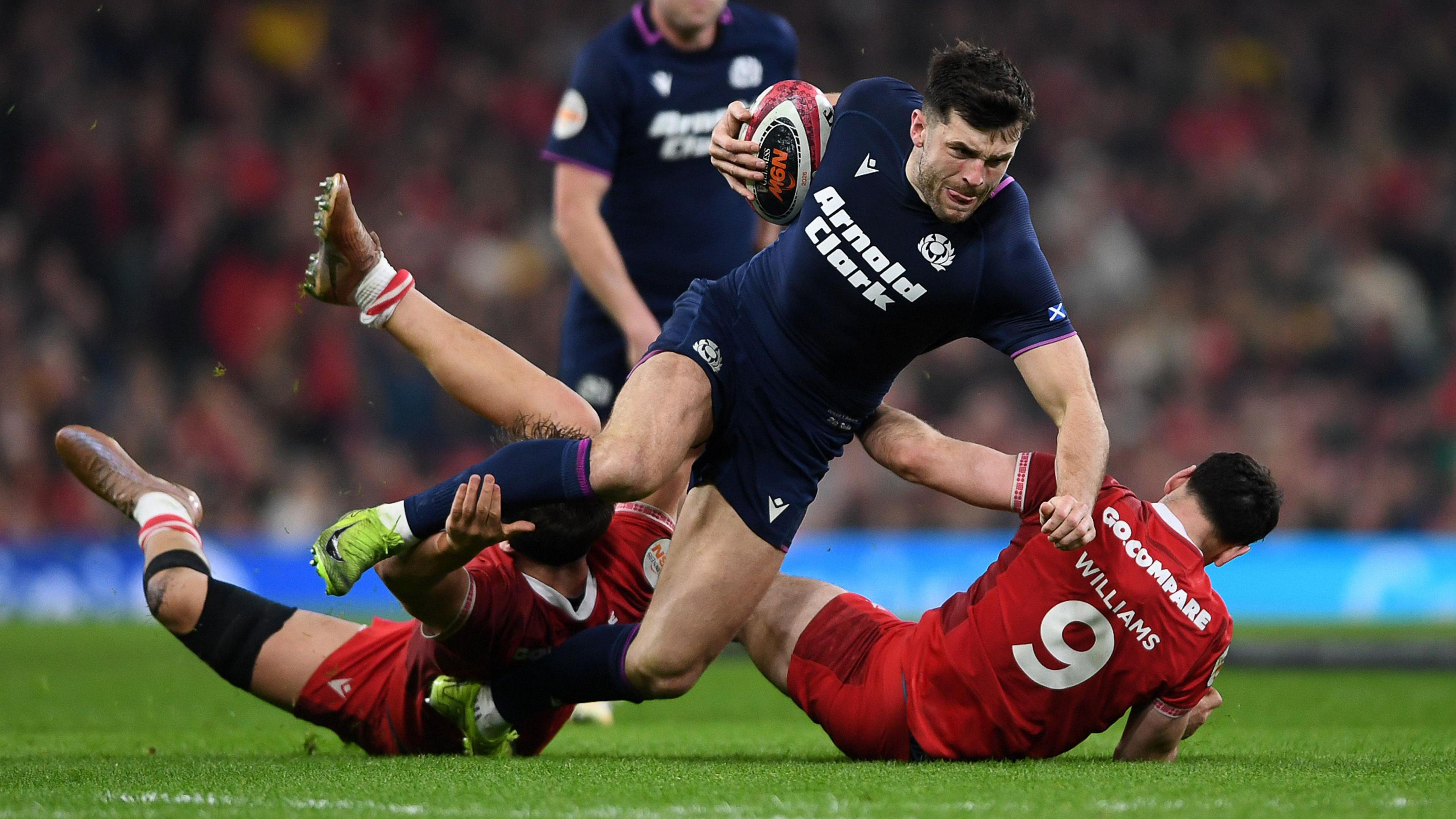 Blair Kinghorn of Scotland is tackled by two Wales defenders