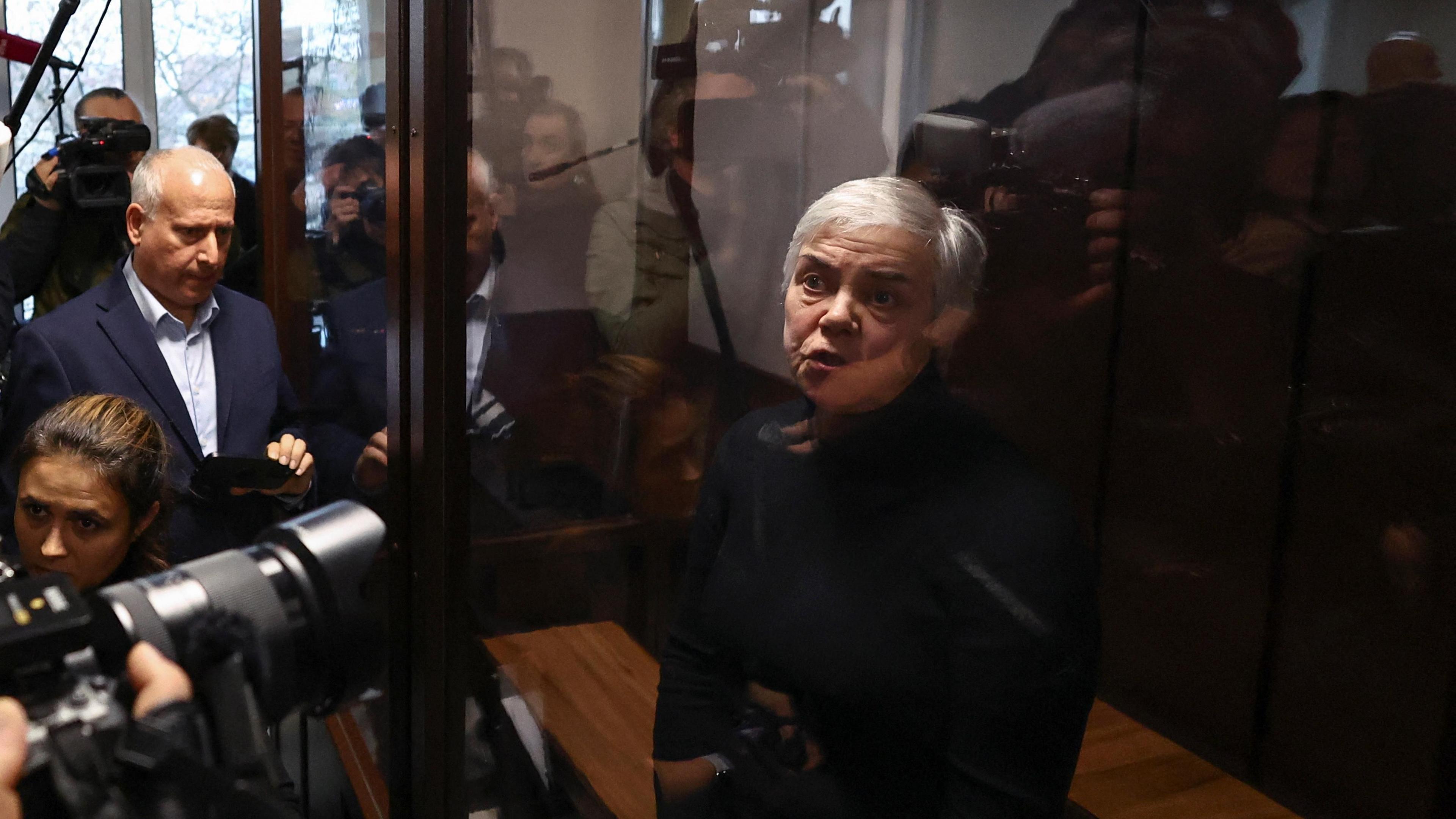 Nadezhda Buyanova, a 68-year-old paediatrician denounced by a patient's mother for an alleged unpatriotic statement and accused of blaming Russia's armed forces for a military conflict against Ukraine, stands inside an enclosure for defendants during a court hearing in Moscow, Russia