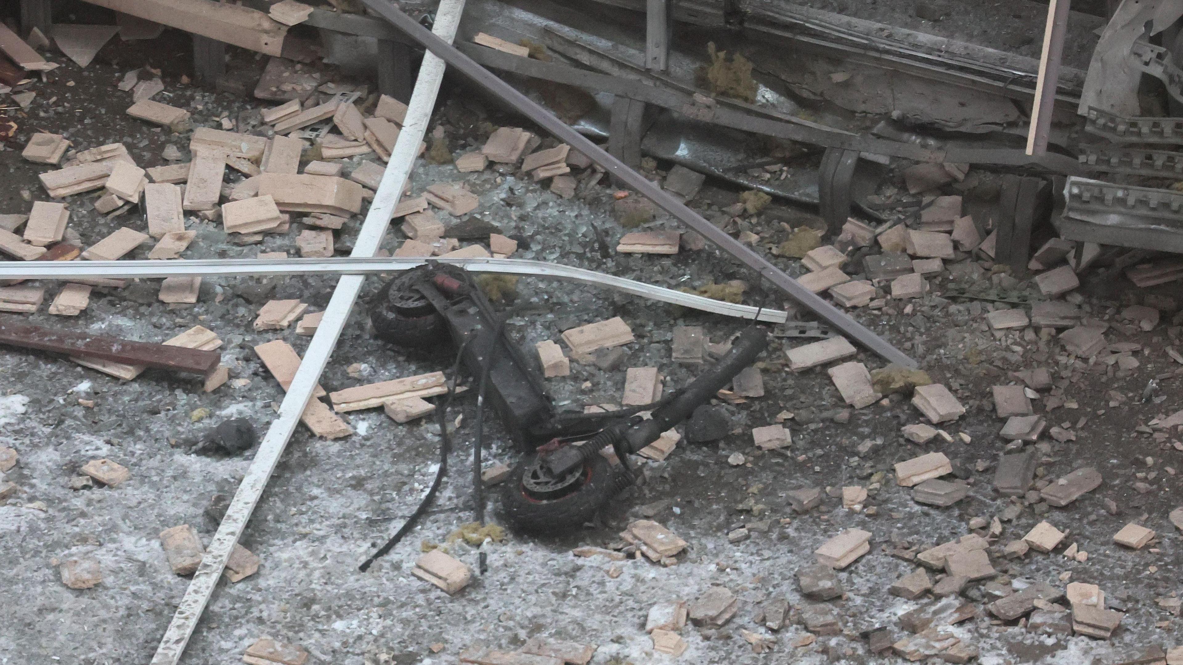 A burnt out scooter, without its handlebars, is seen outside the apartment block where a Russian general and his assistant were killed on 17 December