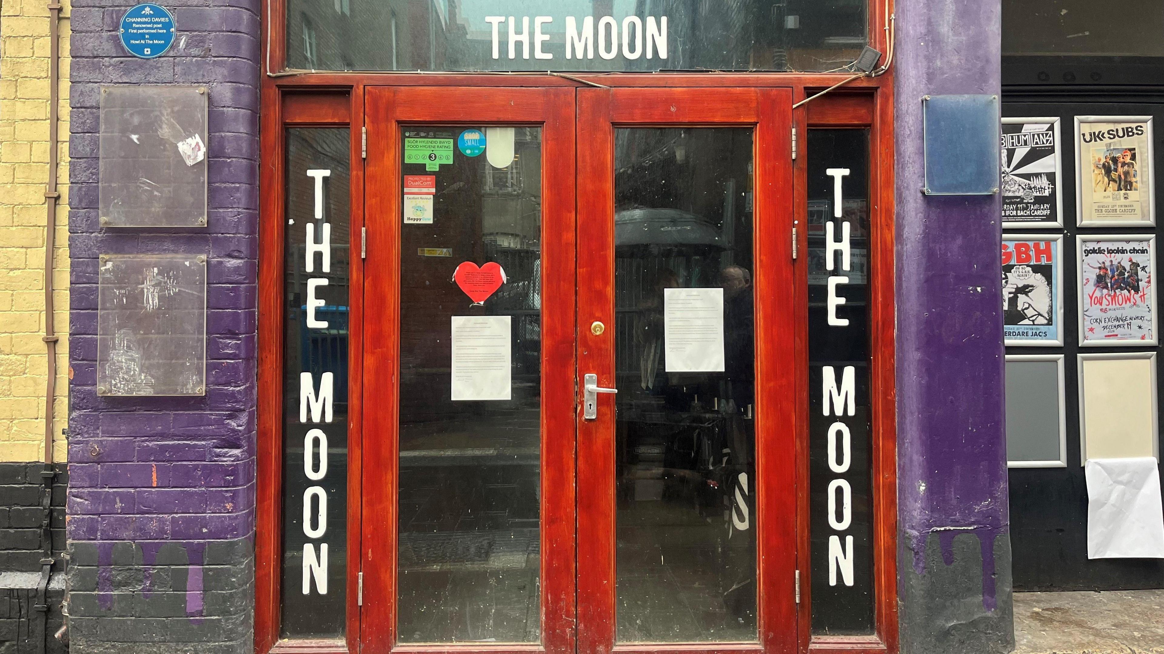 The doors of The Moon on Womanby Street, Cardiff, locked - with posters on the door announcing its closure.