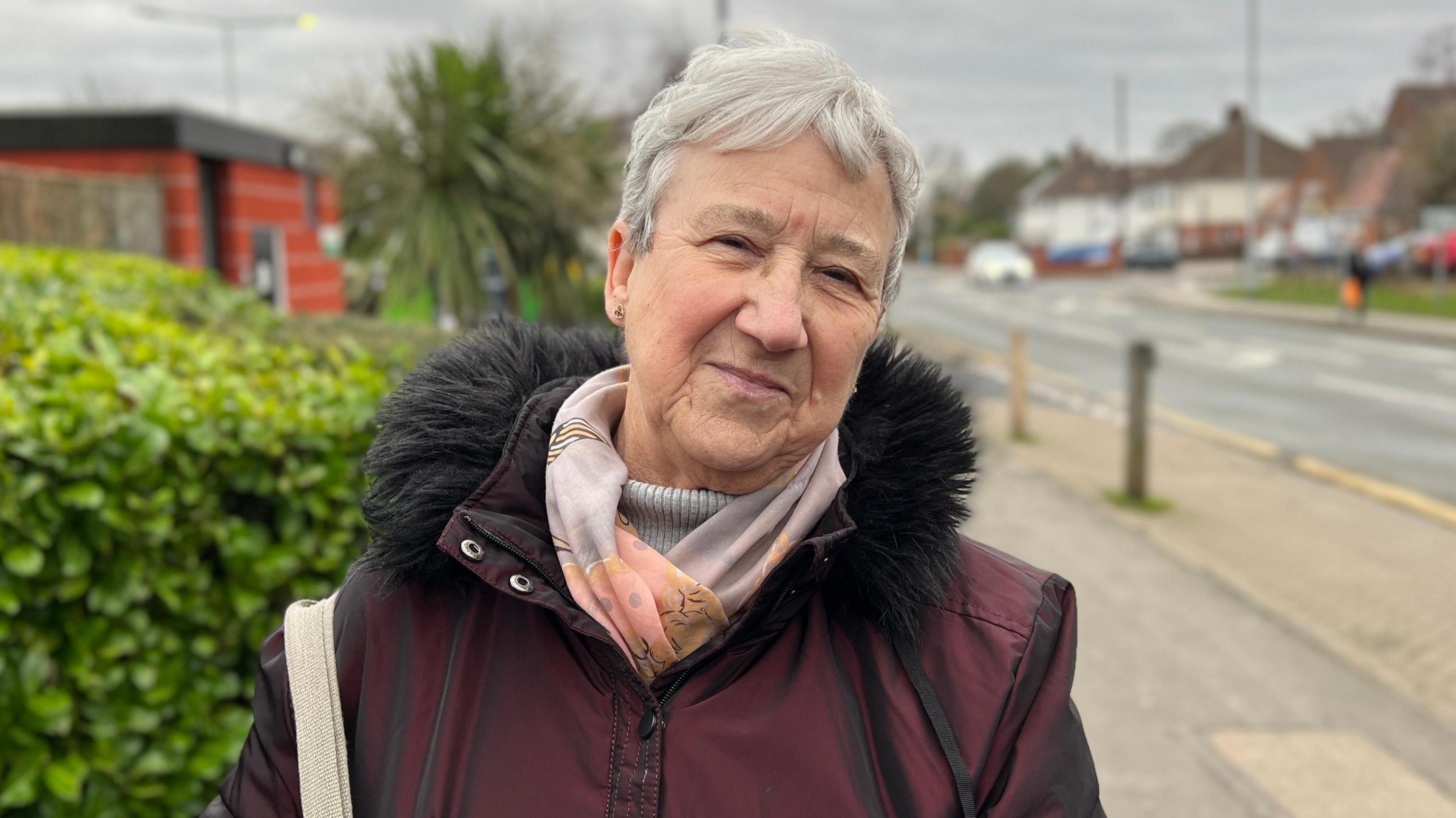 Woman looks into camera on street.