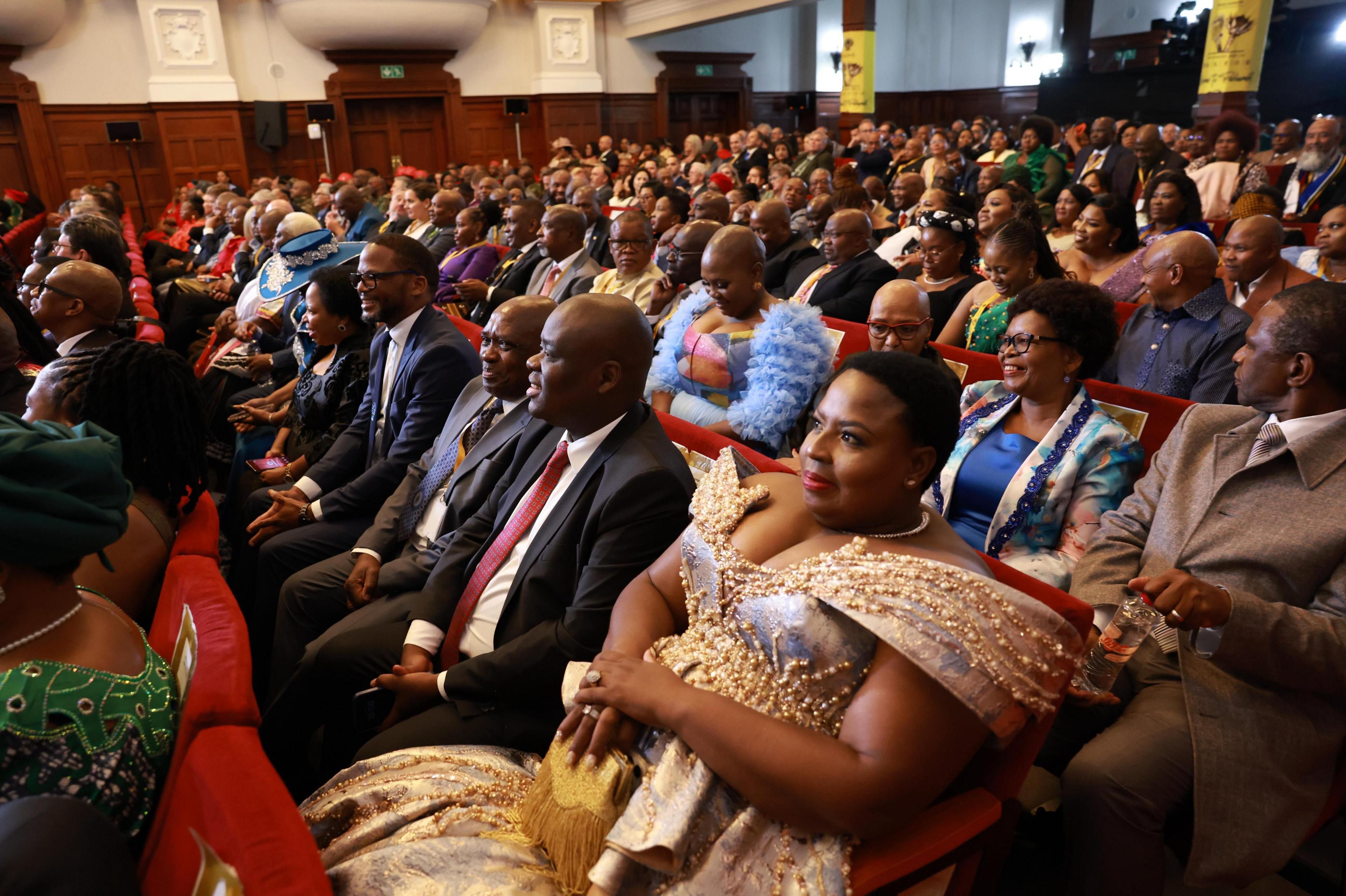 Lindiwe Ntshalintshali, the Deputy Minister of Correctional Services, sits in City Hall in a gold beaded dress as she listens to Cyril Ramaphosa's Sona in Cape Town, South Africa.