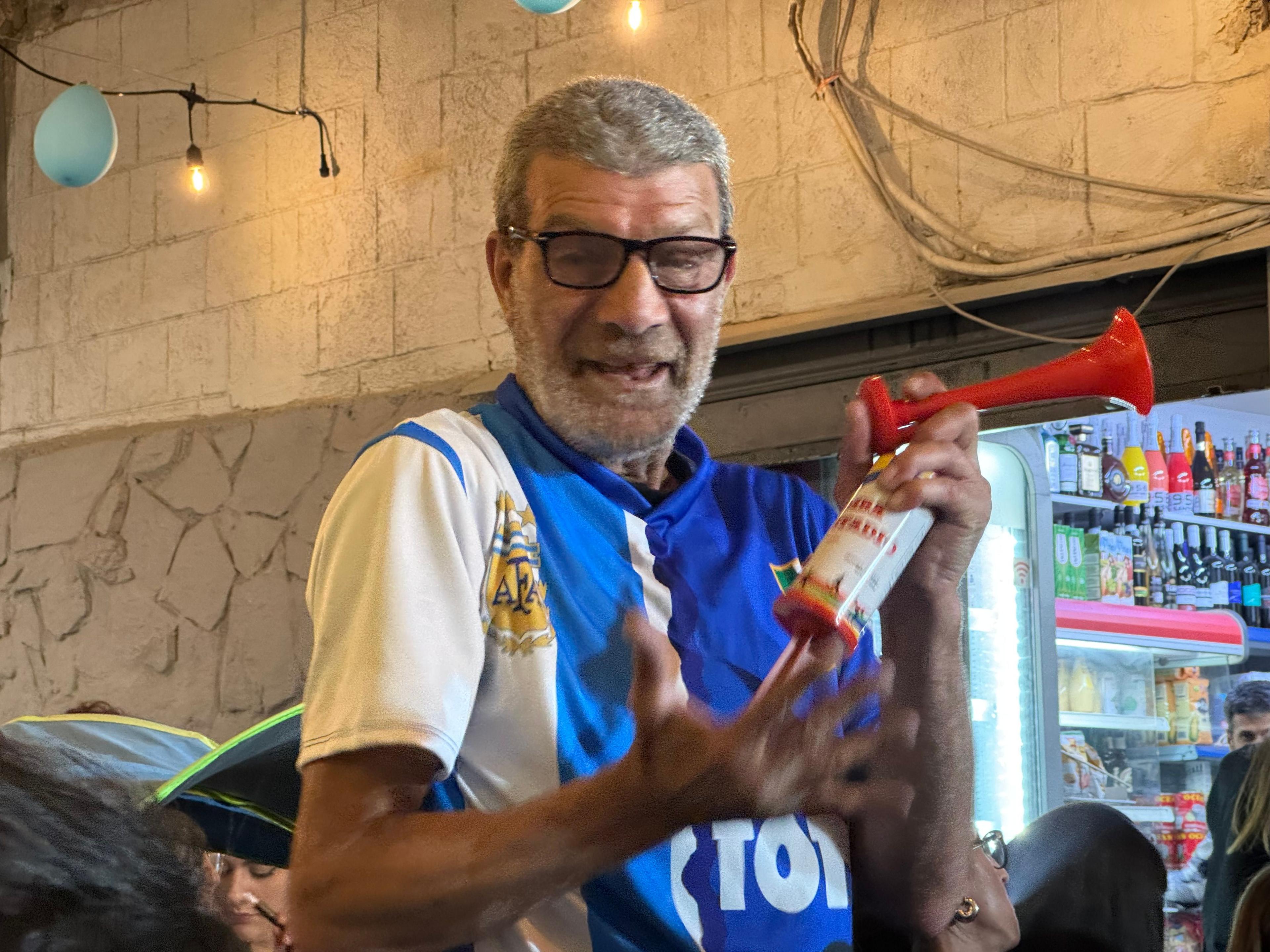 An elderly fan celebrates with an air horn