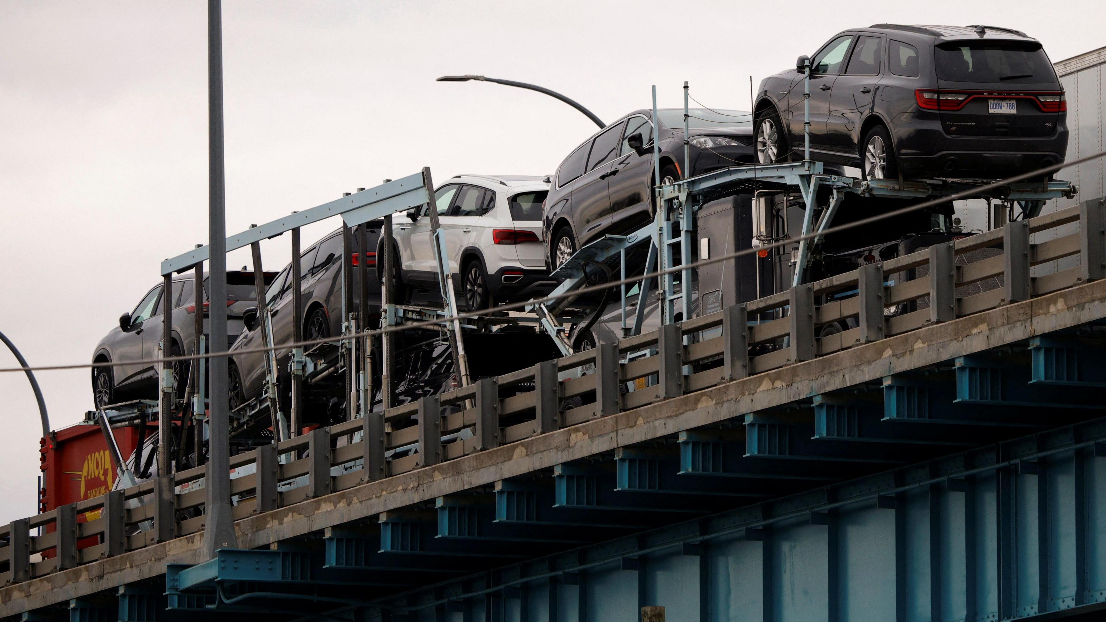 New SUV vehicles cross a bridge from Canada into the United States