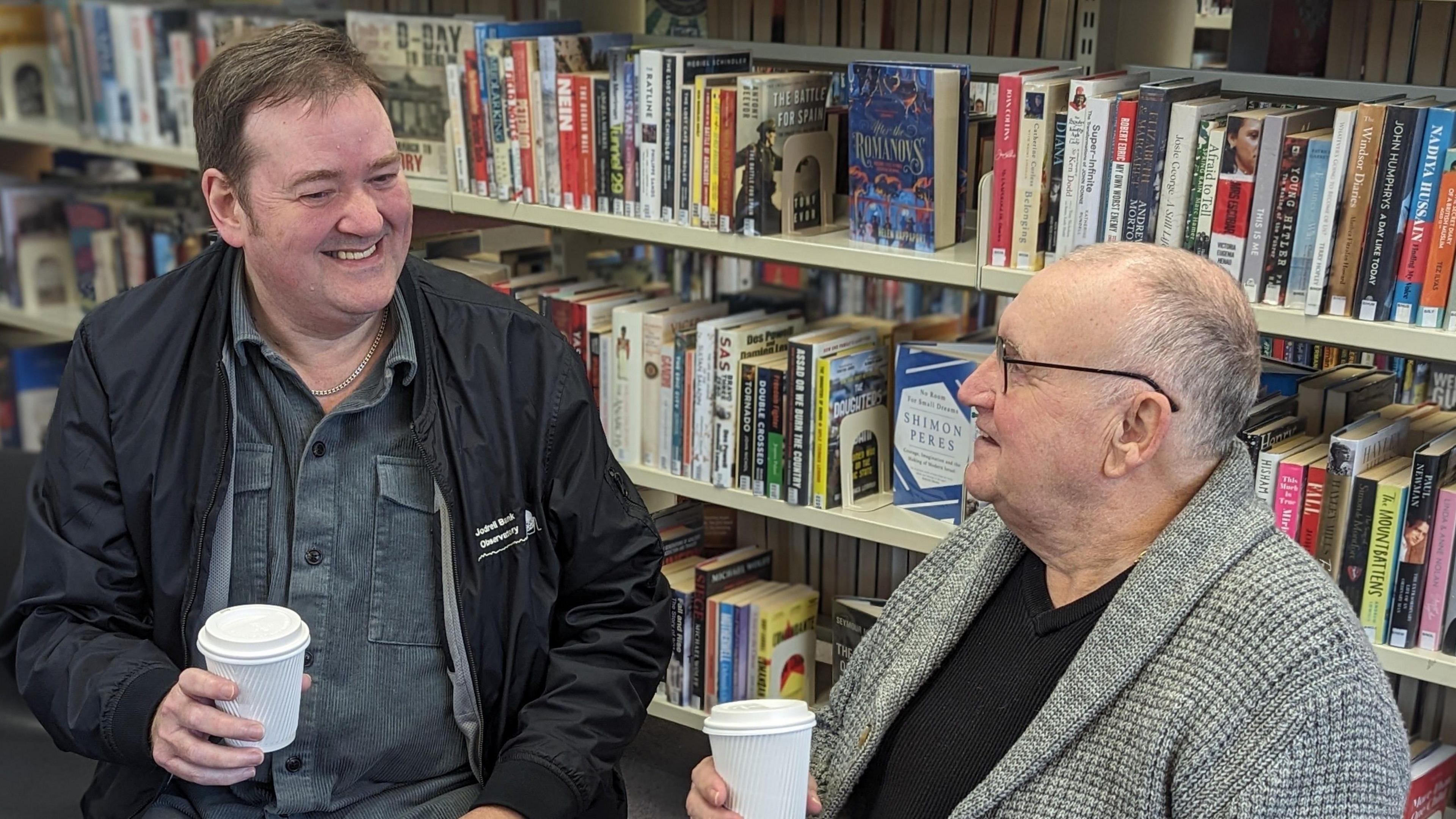 Two men having a conversation in the library