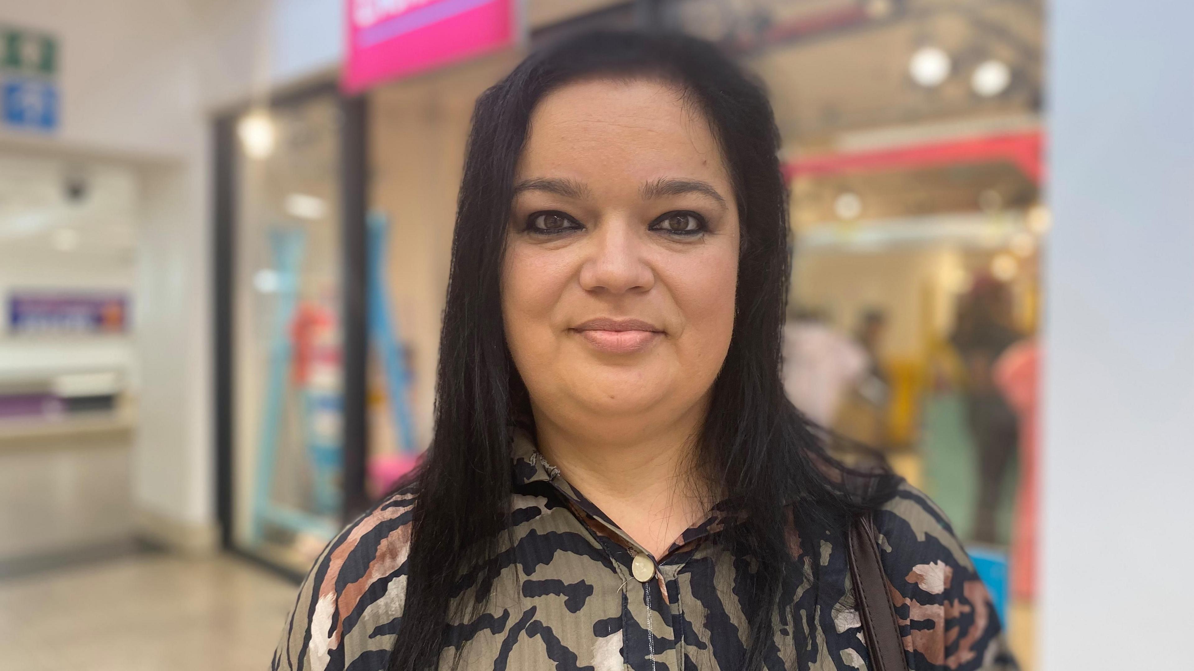 Paulina Gorna-Sow wearing a patterned shirt in front of the uniform exchange store