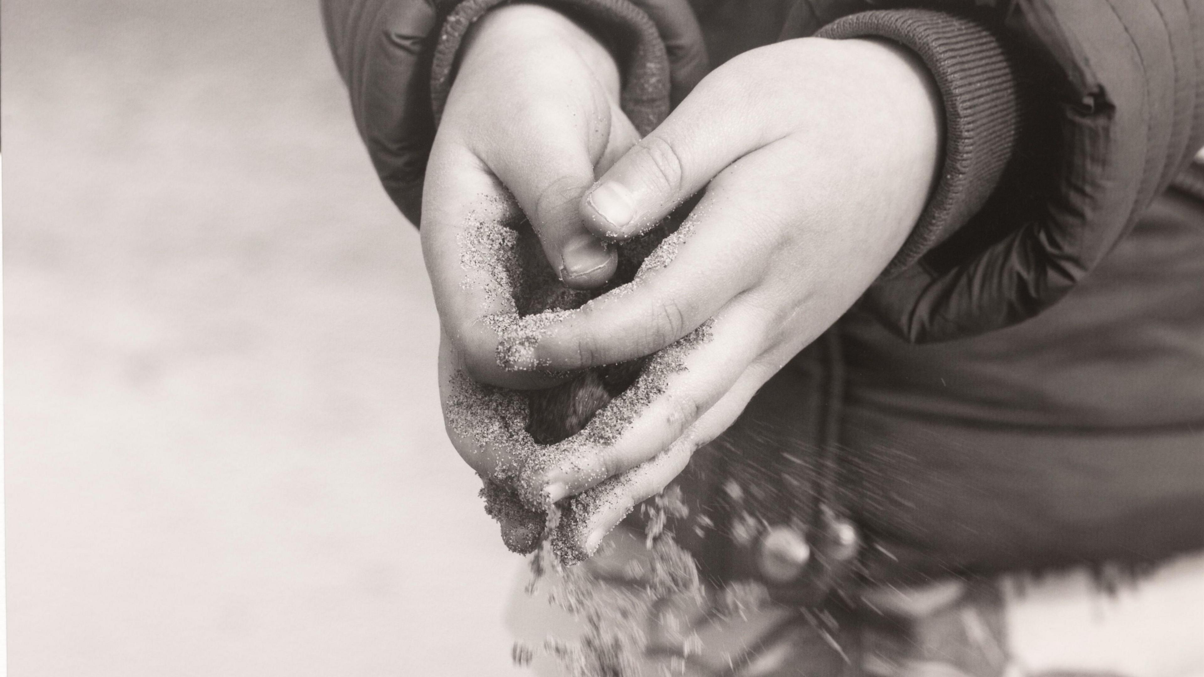 Sand slipping through the hands of Hendrix. The black and white image is part of his mother's final project.