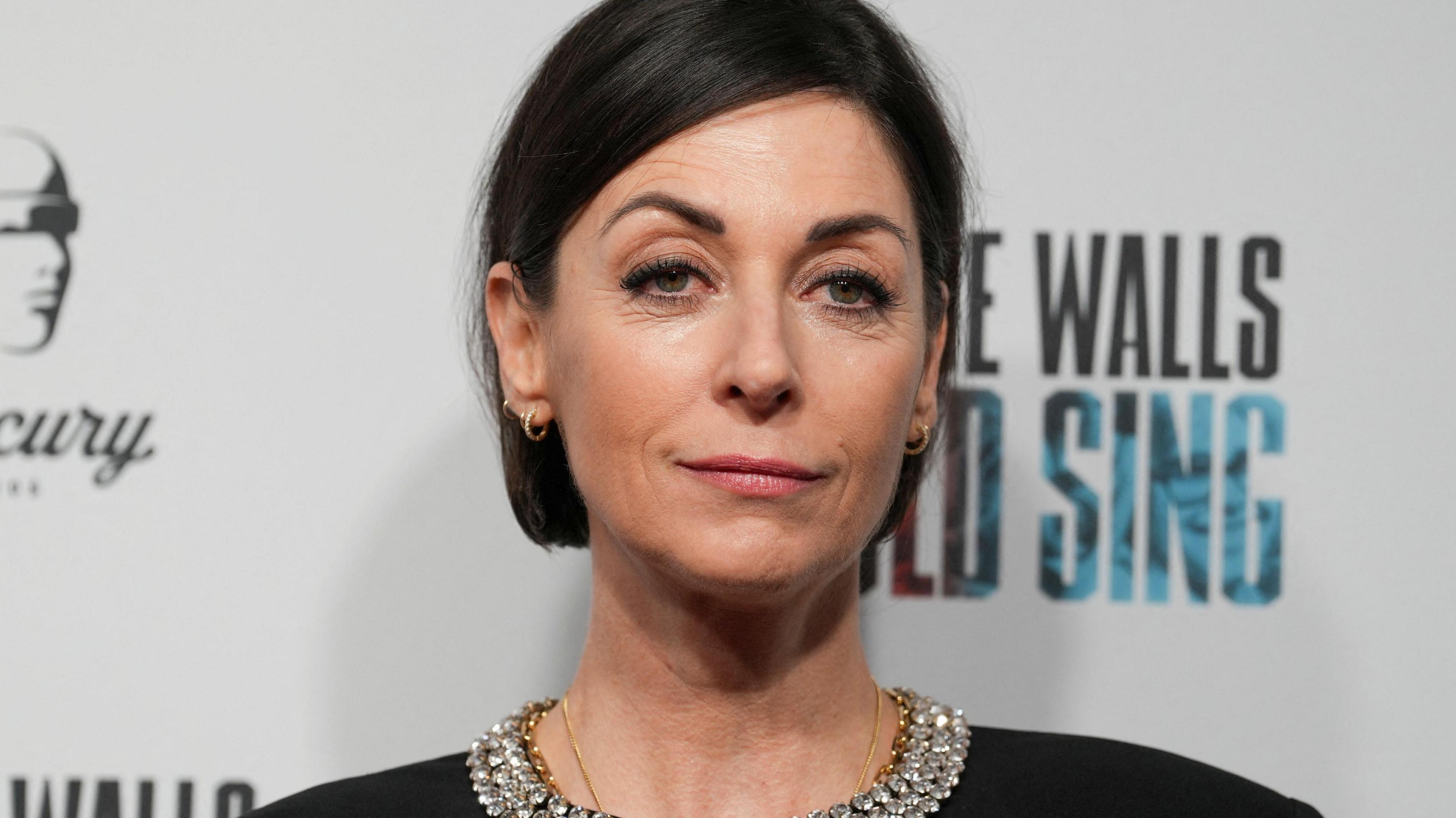 Mary McCartney with black bobbed hair looking impassively wearing a black dress with a diamante choker on the collar at a film premiere in 2022.