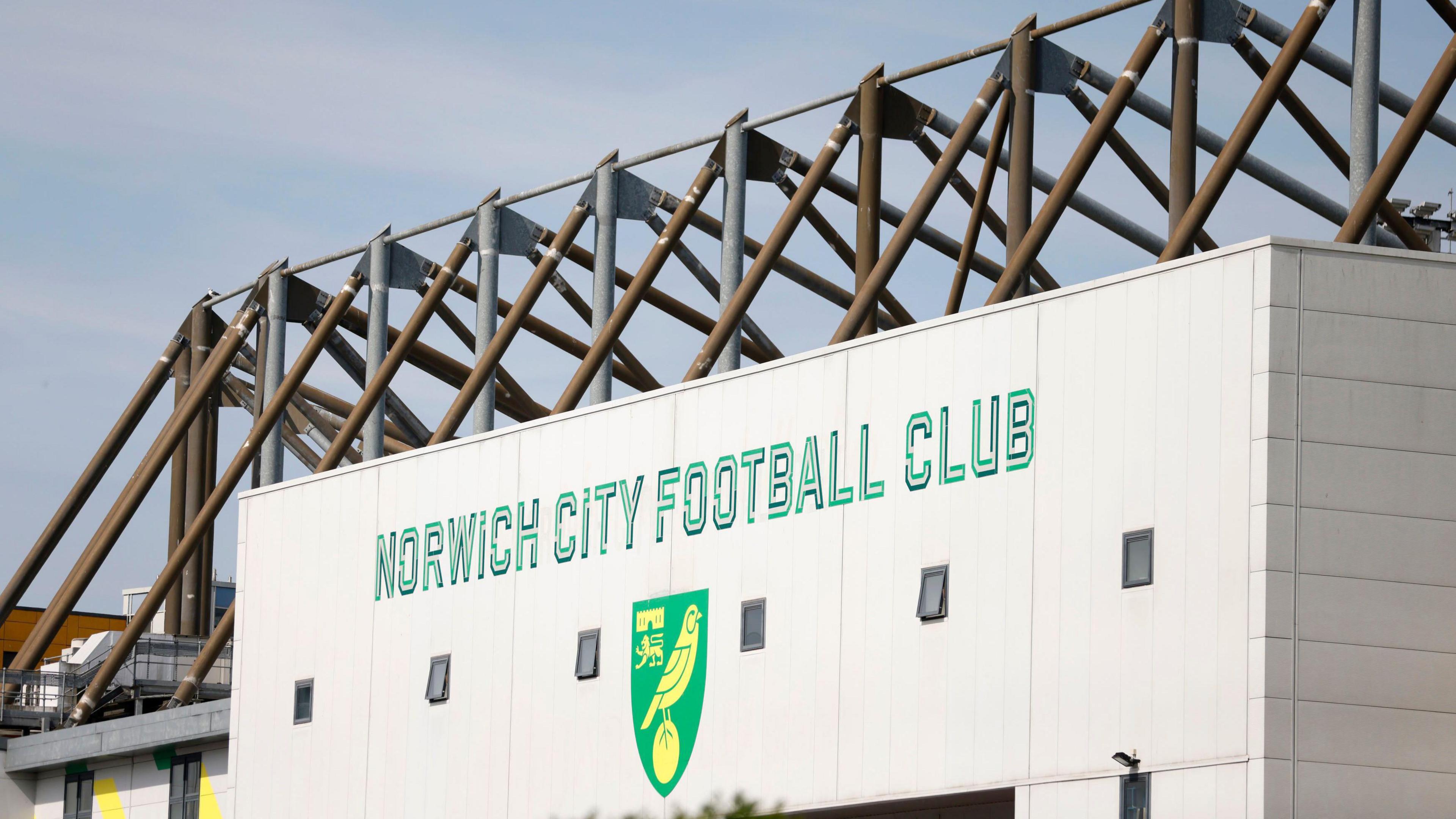 The back of a football stadium stand is shown with the club's name and crest shown on white cladding.