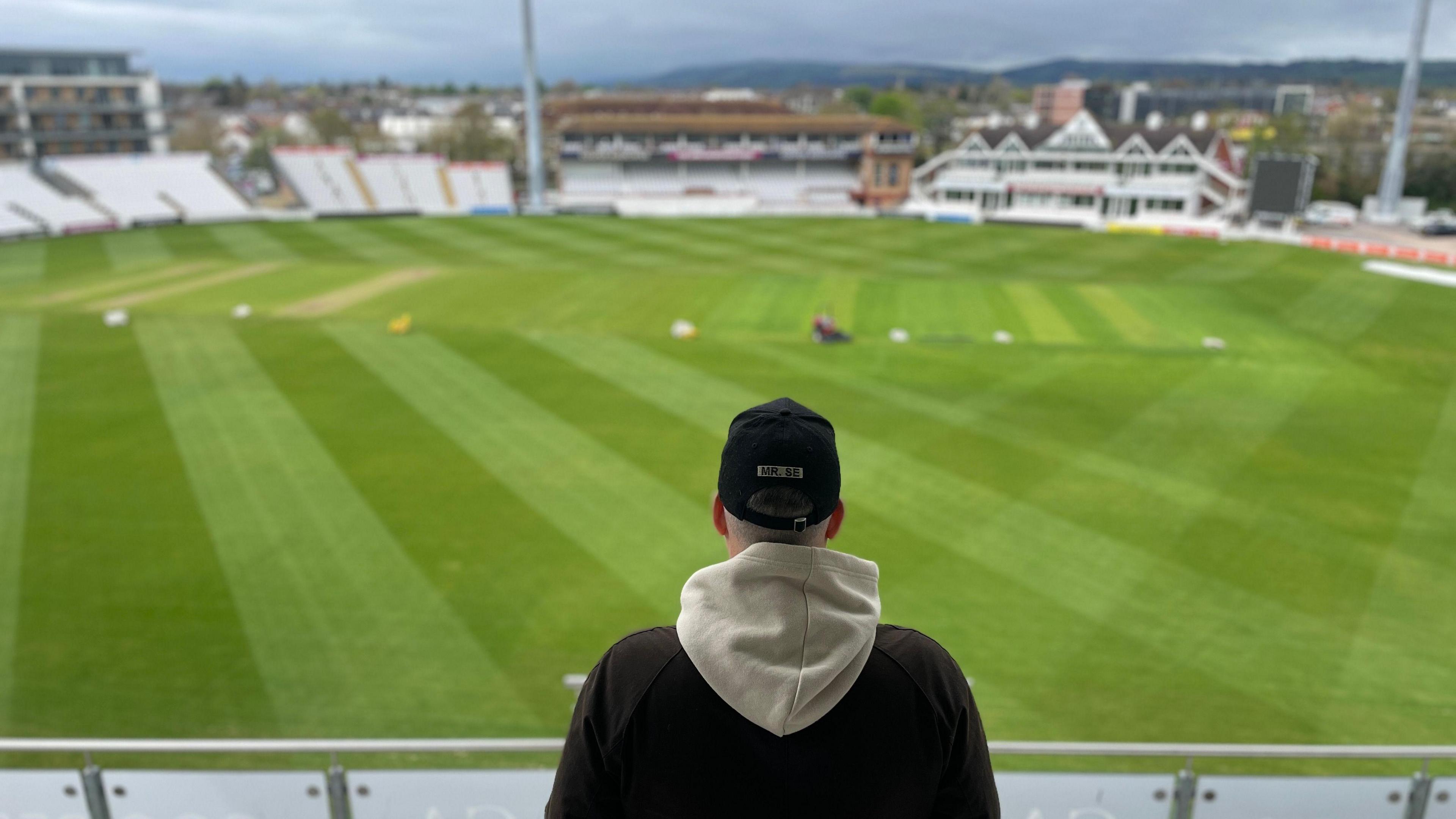 Daniel James wearing a hoodie and a cap overlooking Somerset County Cricket Ground