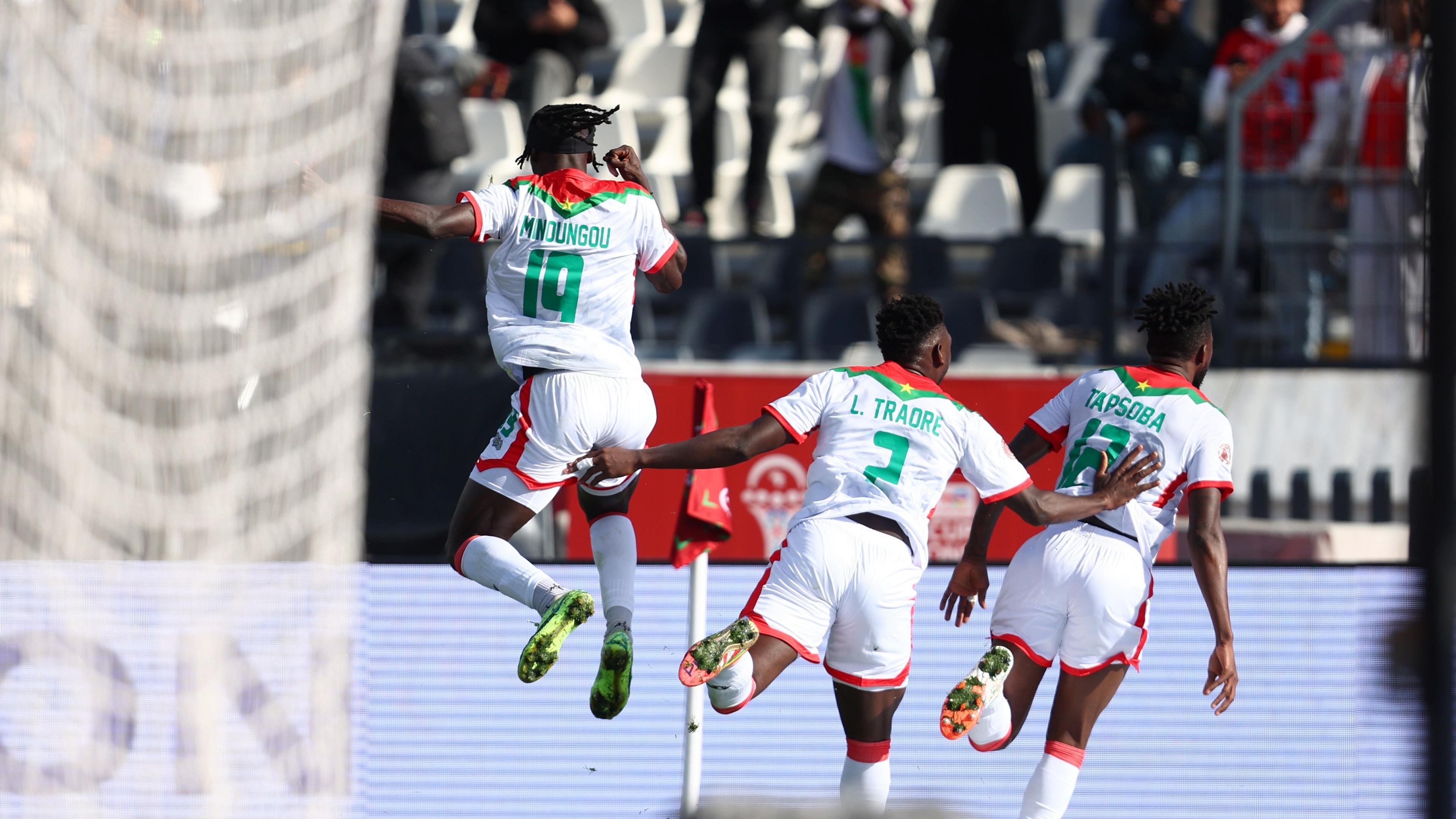 Burkina Faso footballers playing football at Afcon 2025 and running towards the camera in white kit