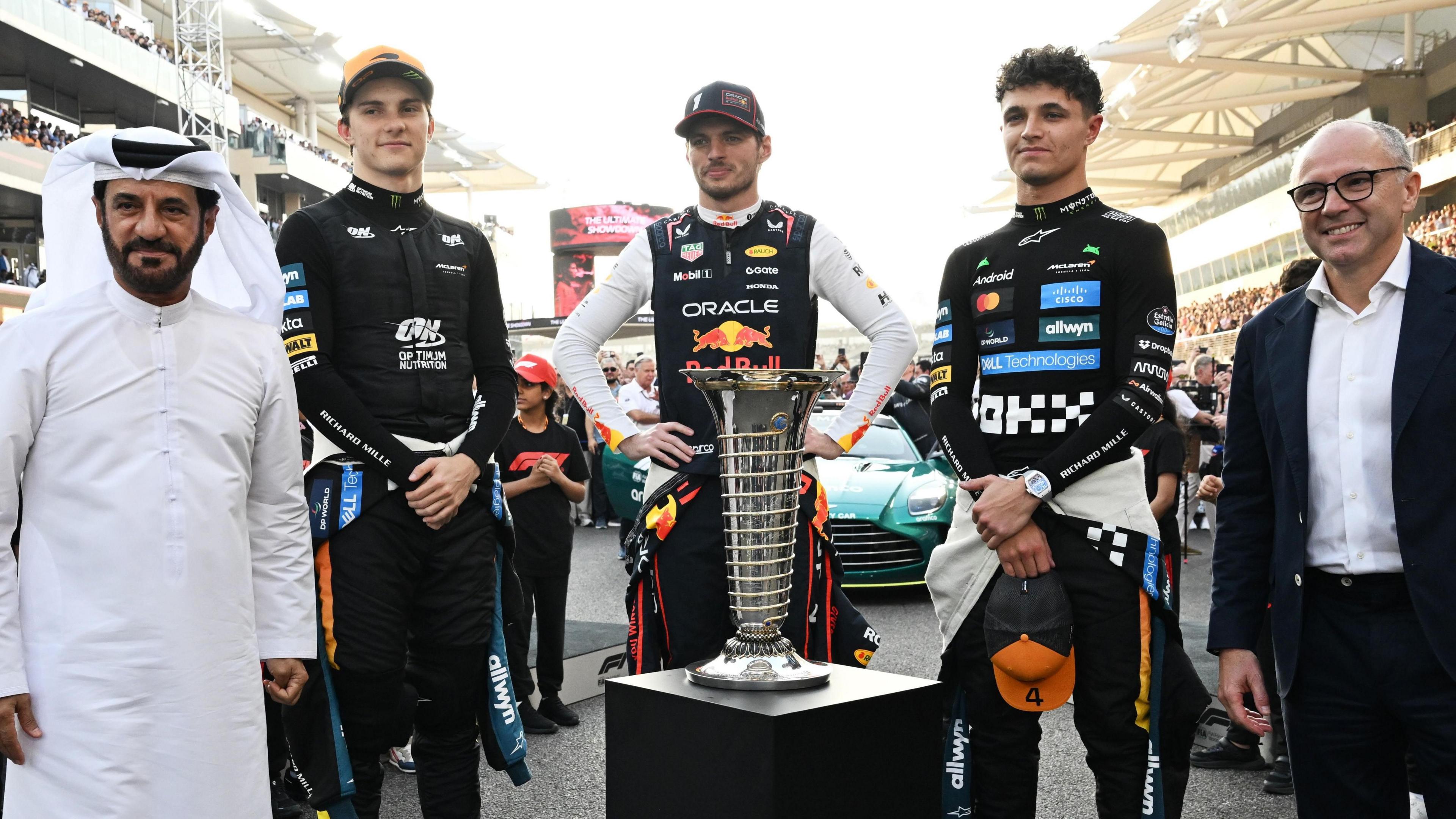 FIA president Mohammed Ben Sulayem, McLaren's Oscar Piastri, Red Bull's Max Verstappen, McLaren's Lando Norris and F1 president Stefano Domenicali pose with the FIA F1 drivers' championship trophy before the Abu Dhabi Grand Prix