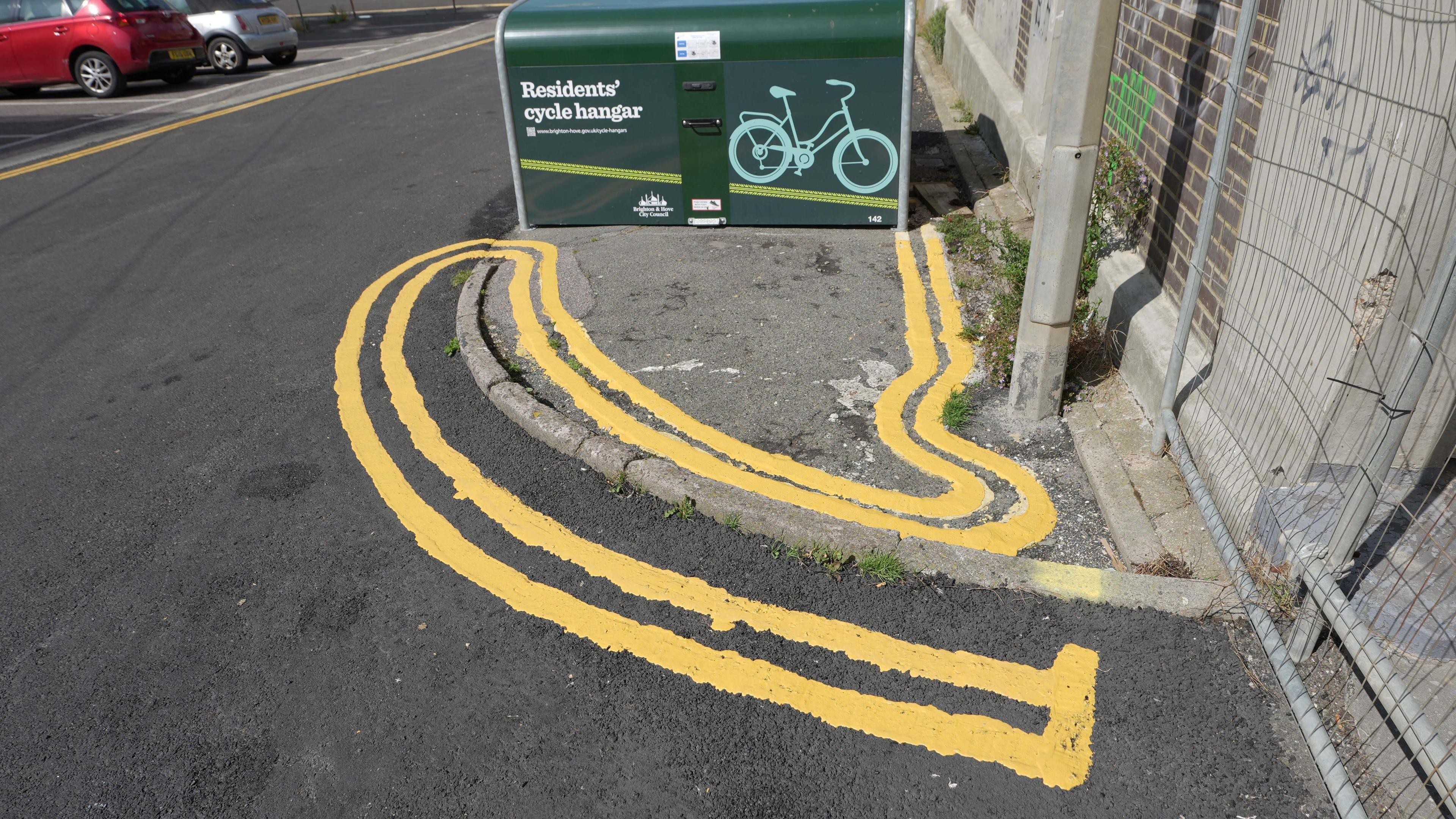 Double yellow lines snake back on themselves around a kerb. 