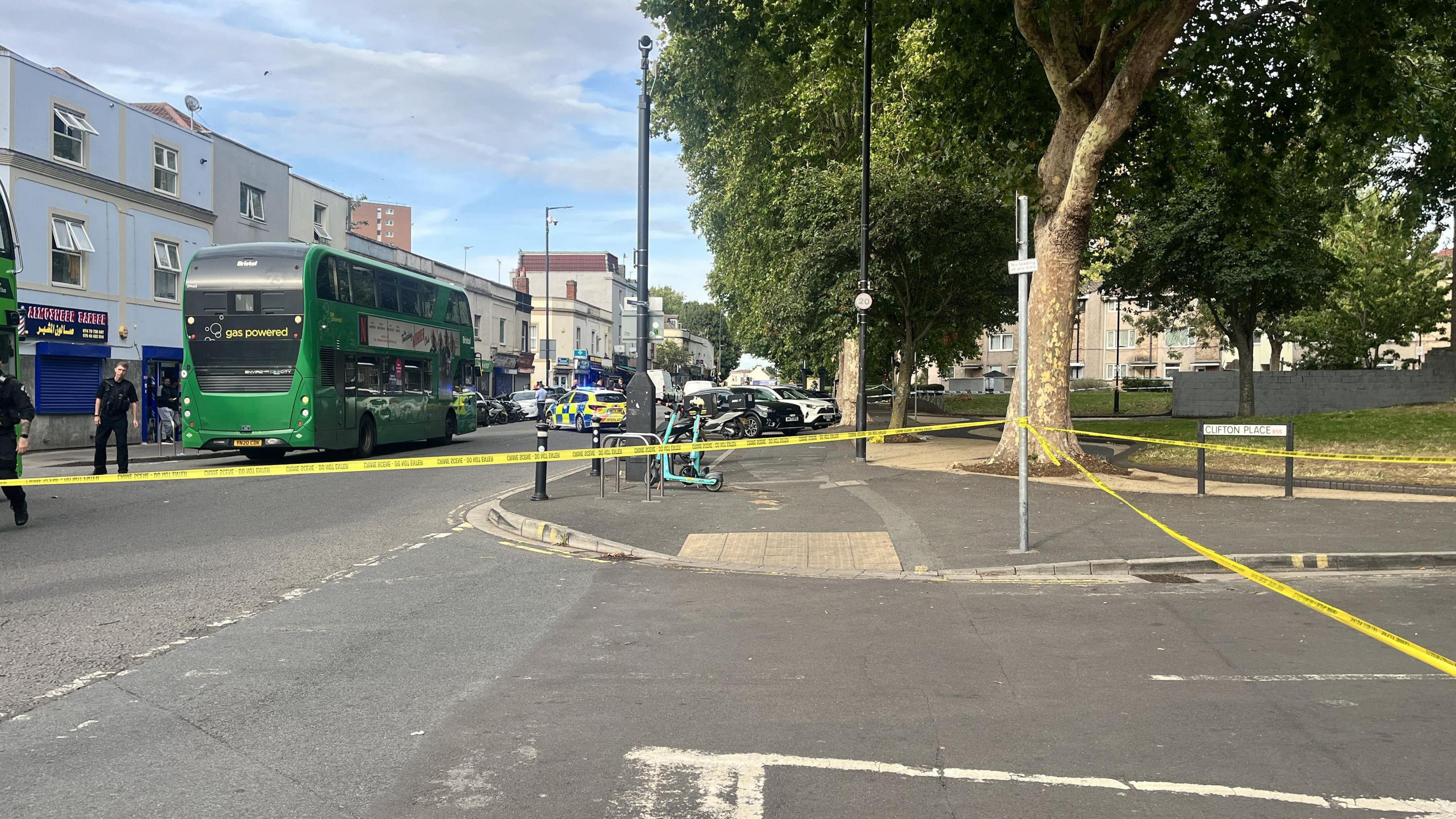 Police tape on Stapleton Road. There is a bus within the police cordon, with a number of police offices and vehicles nearby.
