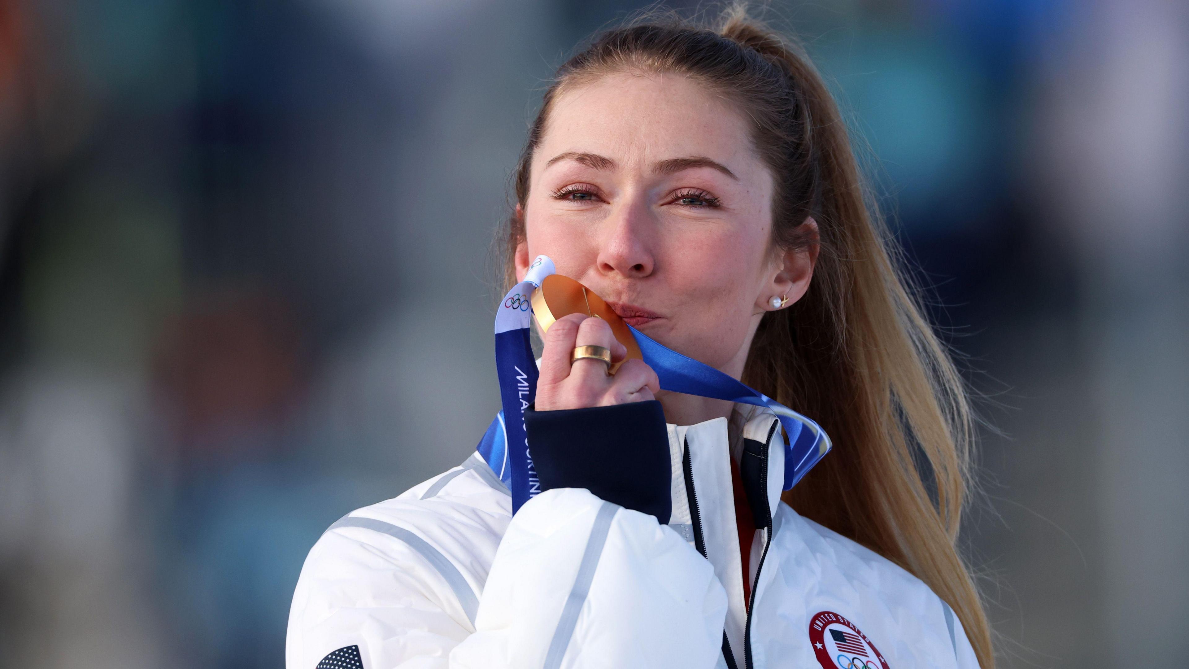 Mikaela Shiffrinová líbá medaili poté, co vyhrála olympijské zlato v Cortině ve slalomu