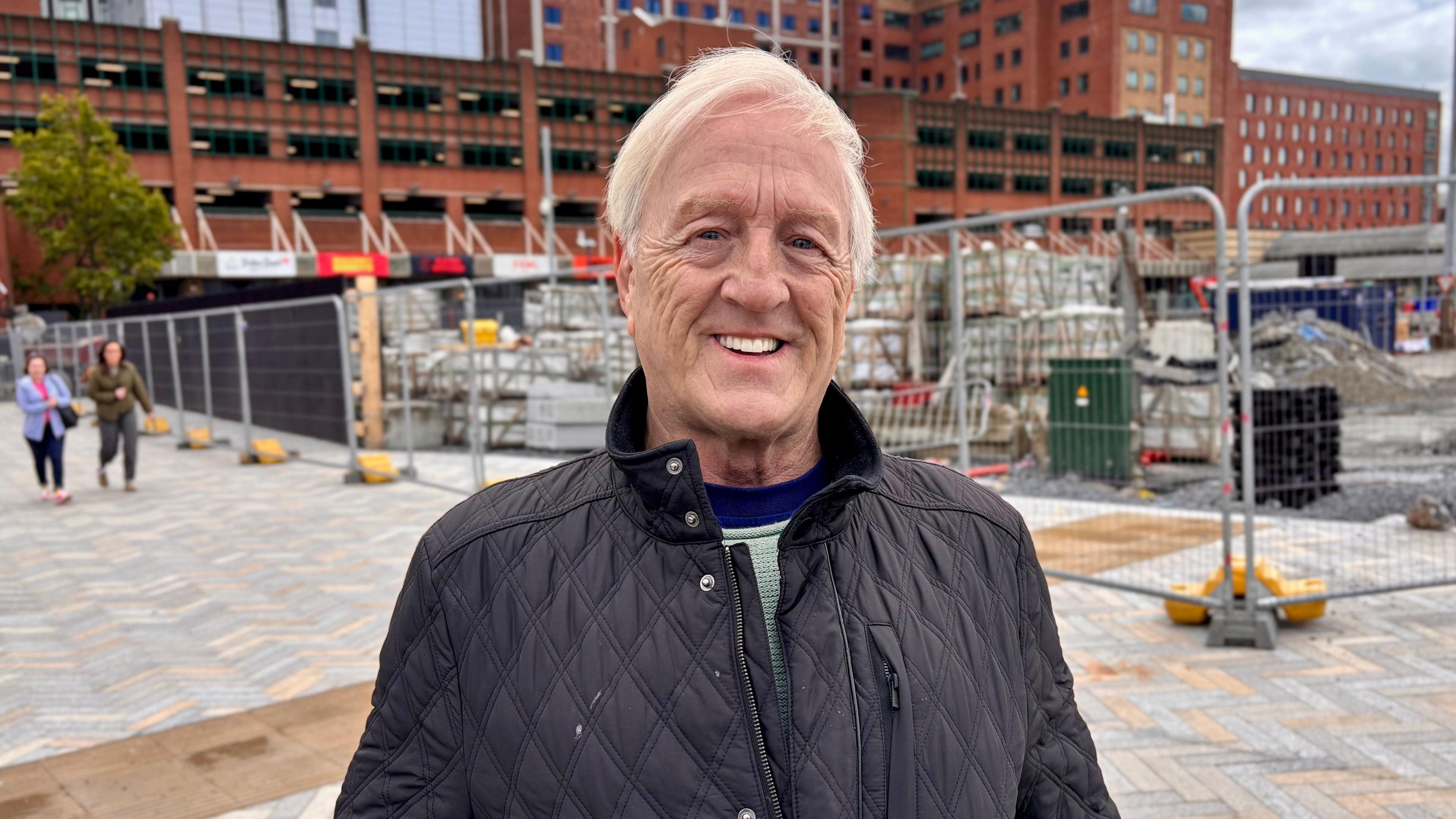 Melvin Egan. He has short white hair, wearing a black waterproof jacket.