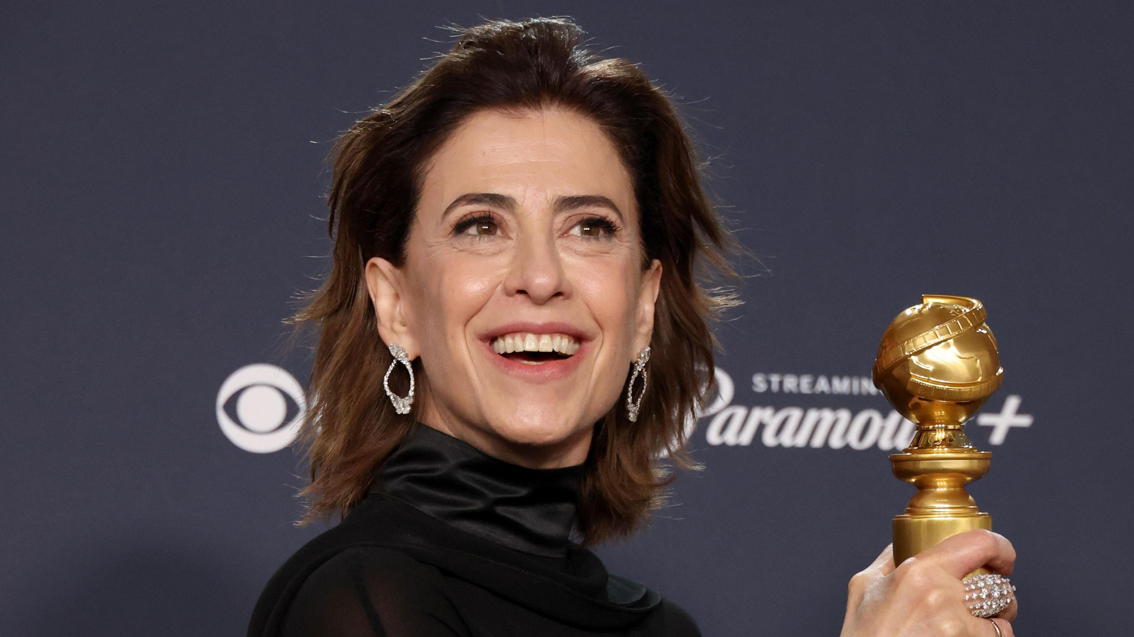 Fernanda Torres holding the Golden Globe award 