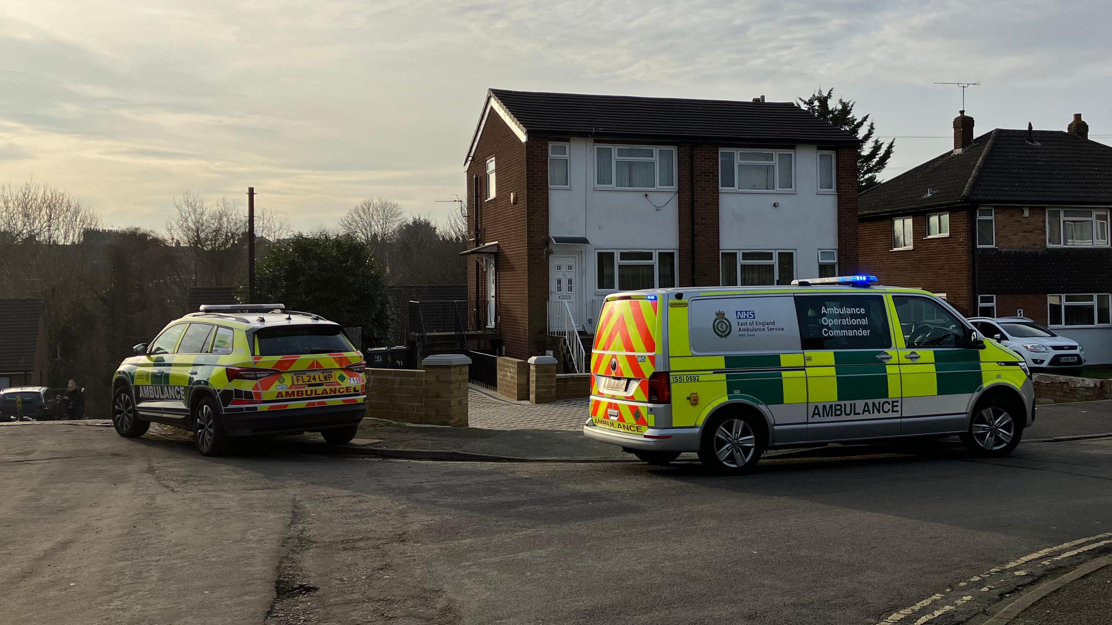 Two ambulance service vehicles outside a property in a residential street