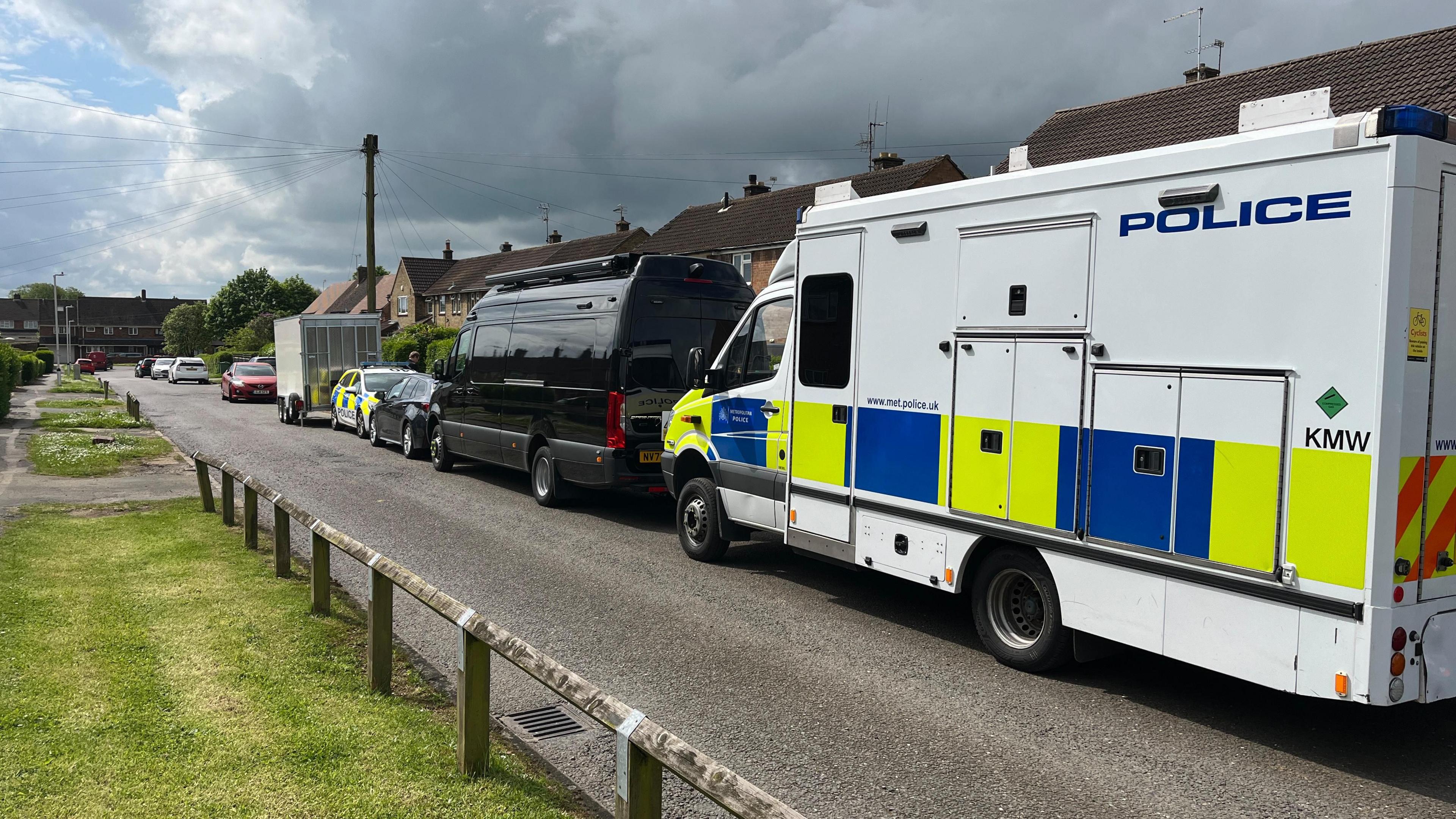 A large police van outside the house in Caddington 