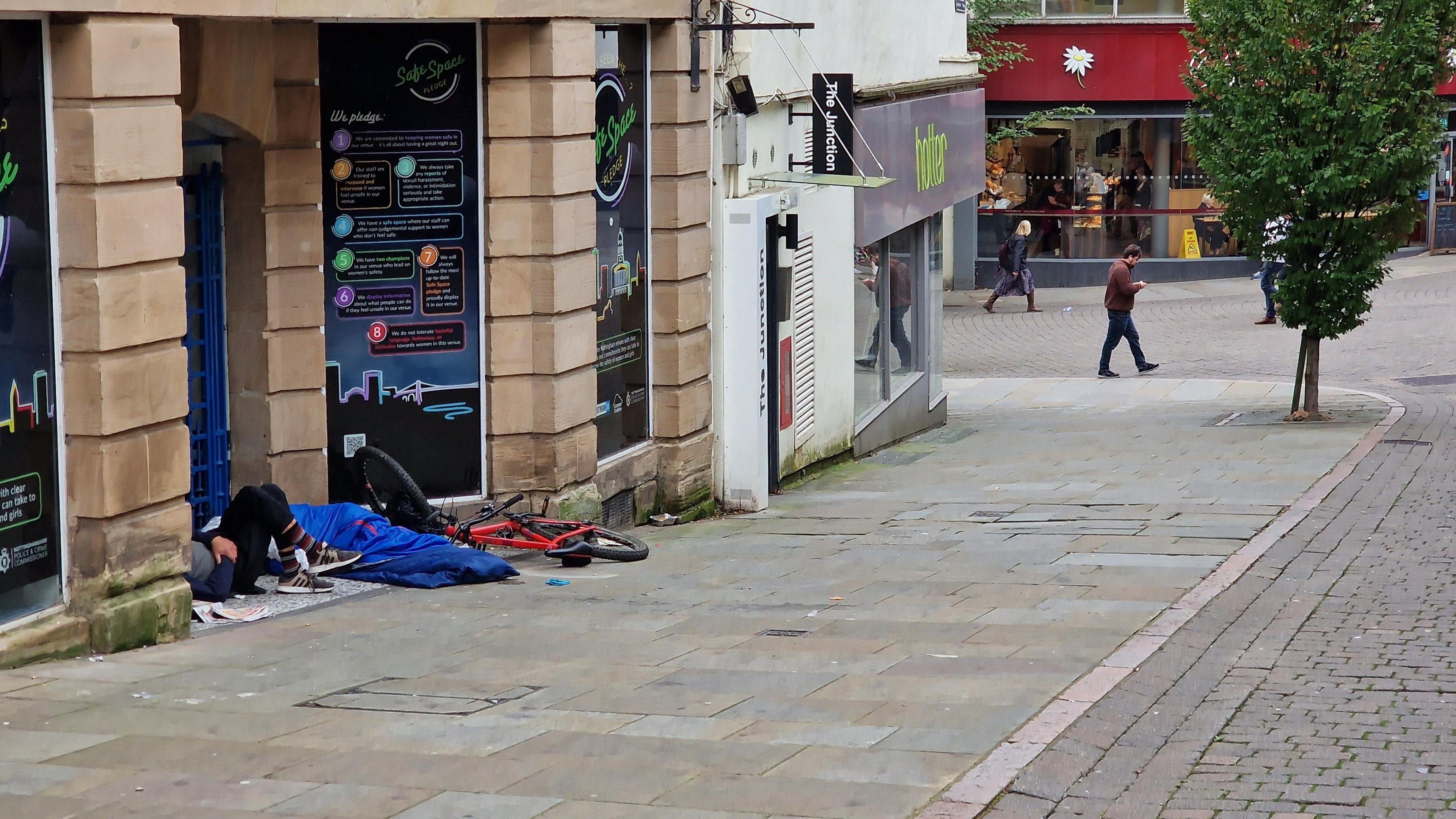 A sleeping bag and bicycle in a shopfront in Nottingham city centre