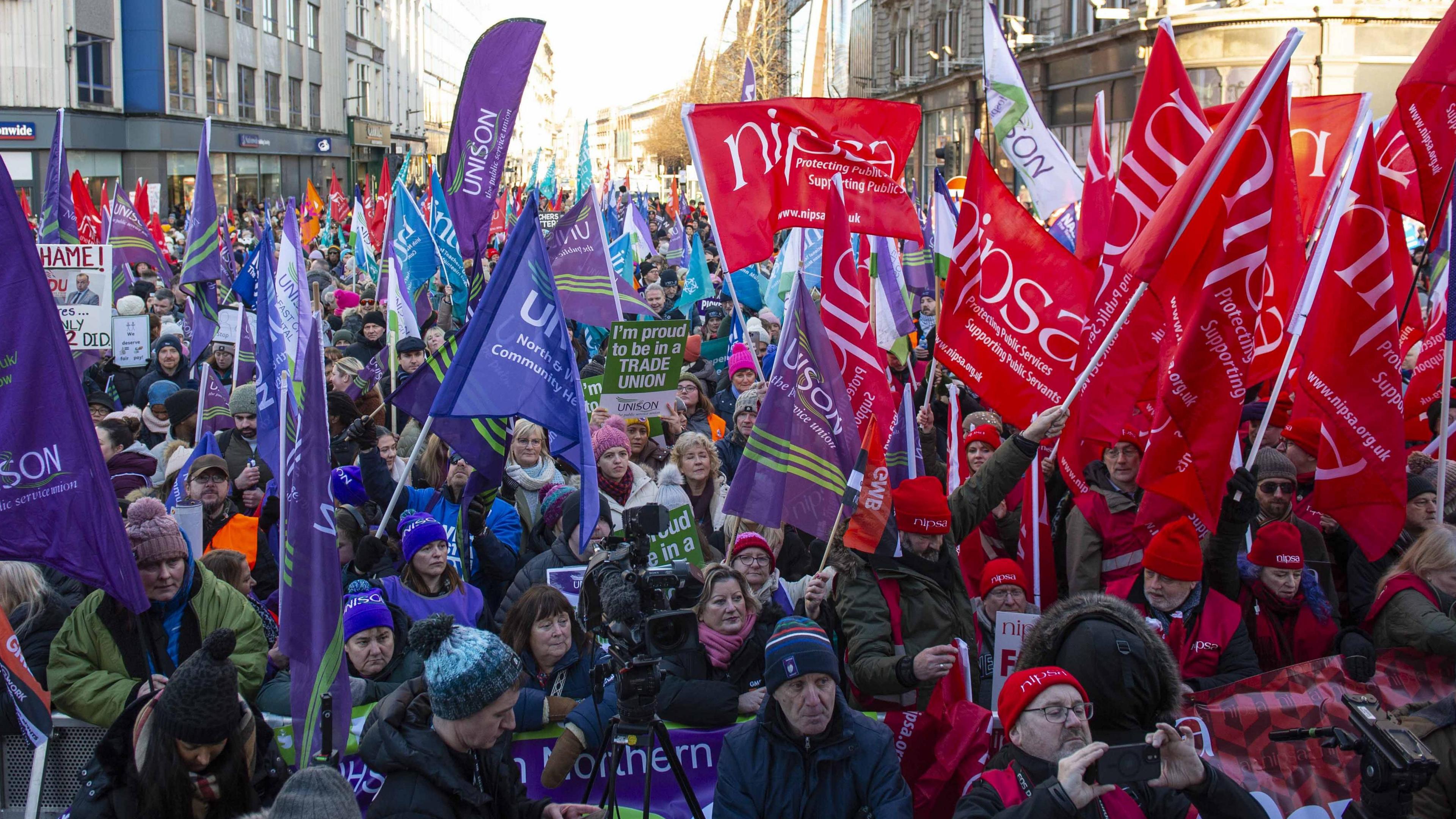 Workers march towards Belfast City Hall during a public sector strike in January