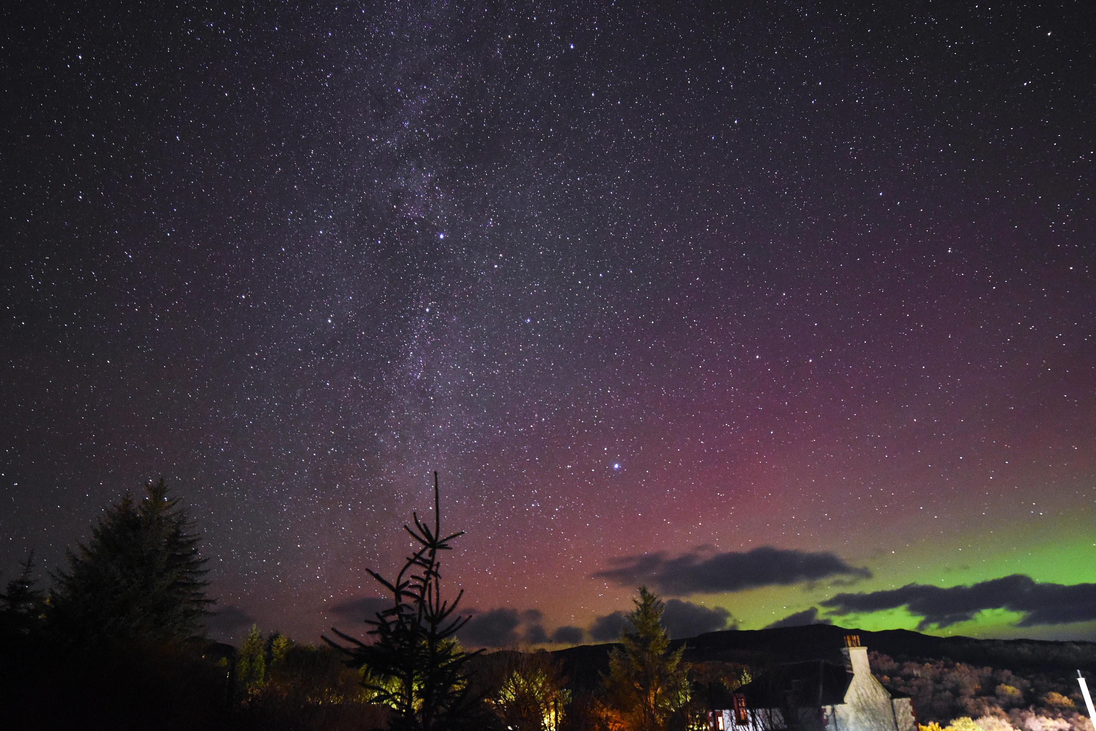 A Islay starry sky is coloured with the lights from the aurora