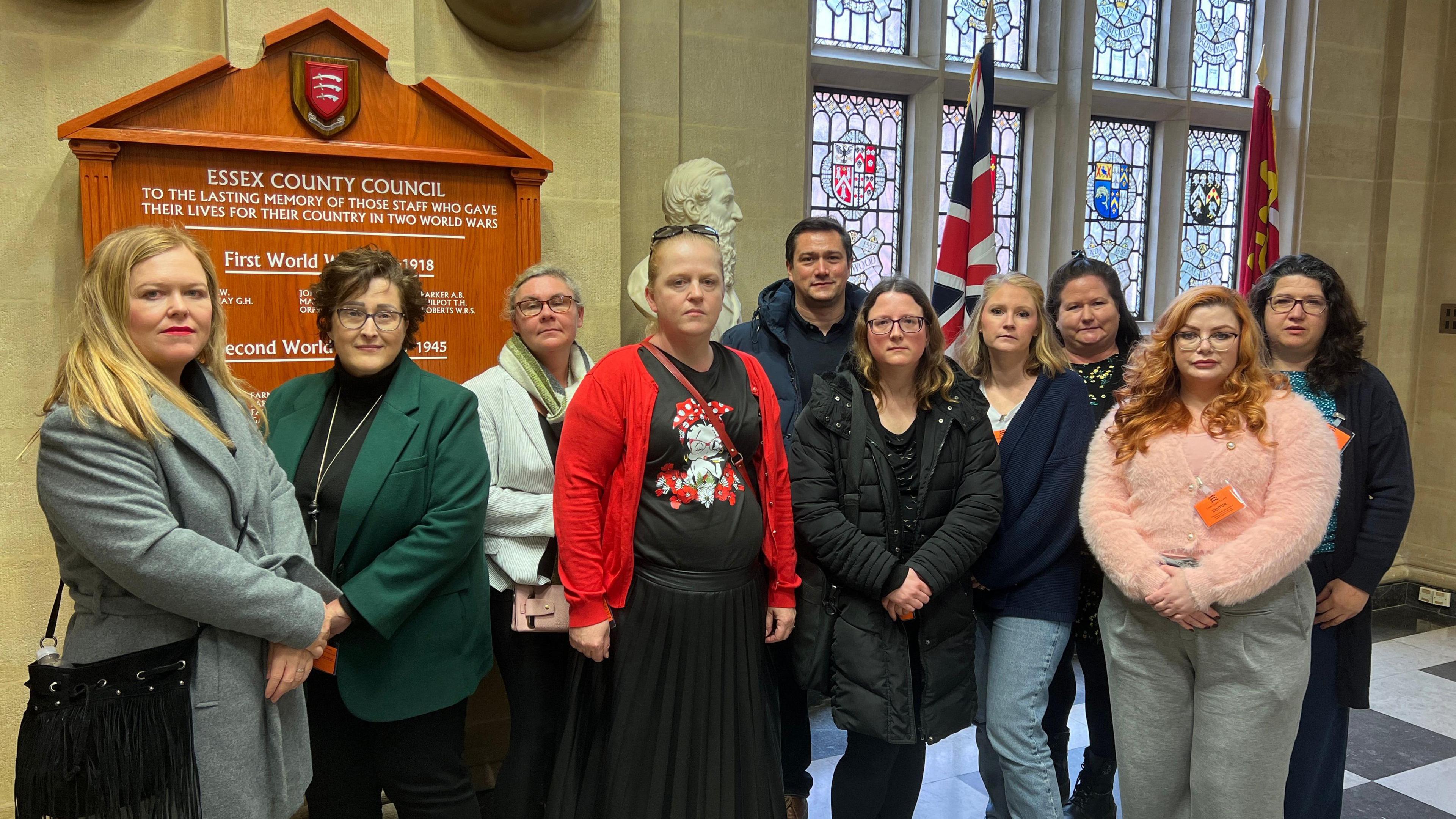 10 parents posing for a photograph looking disgruntled outside Essex County Hall's chamber in 2024.