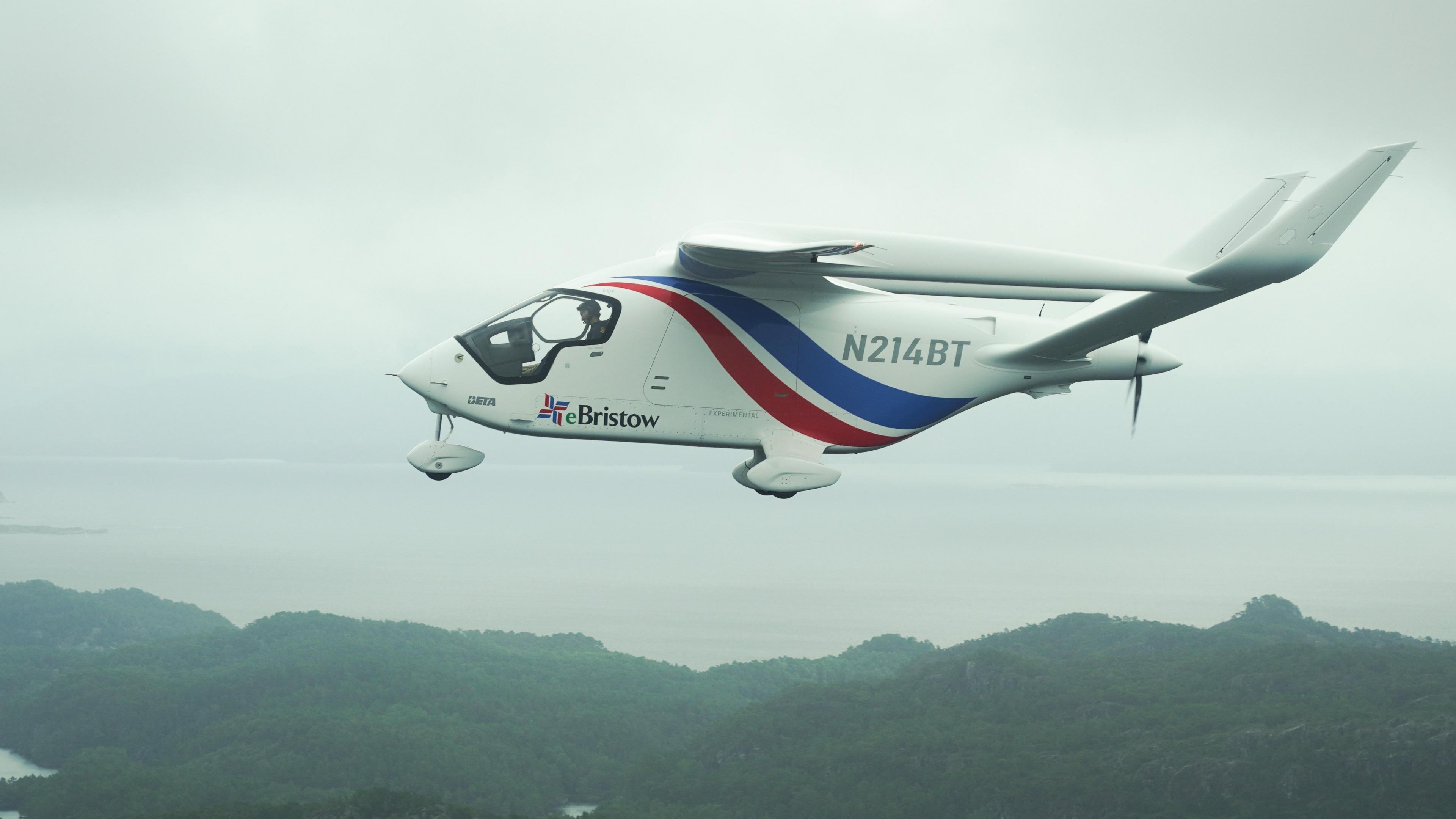 The electric aircraft Alia in flight. It's a small aircraft with one propeller at the back and a blue and red stripes on the white fuselage.