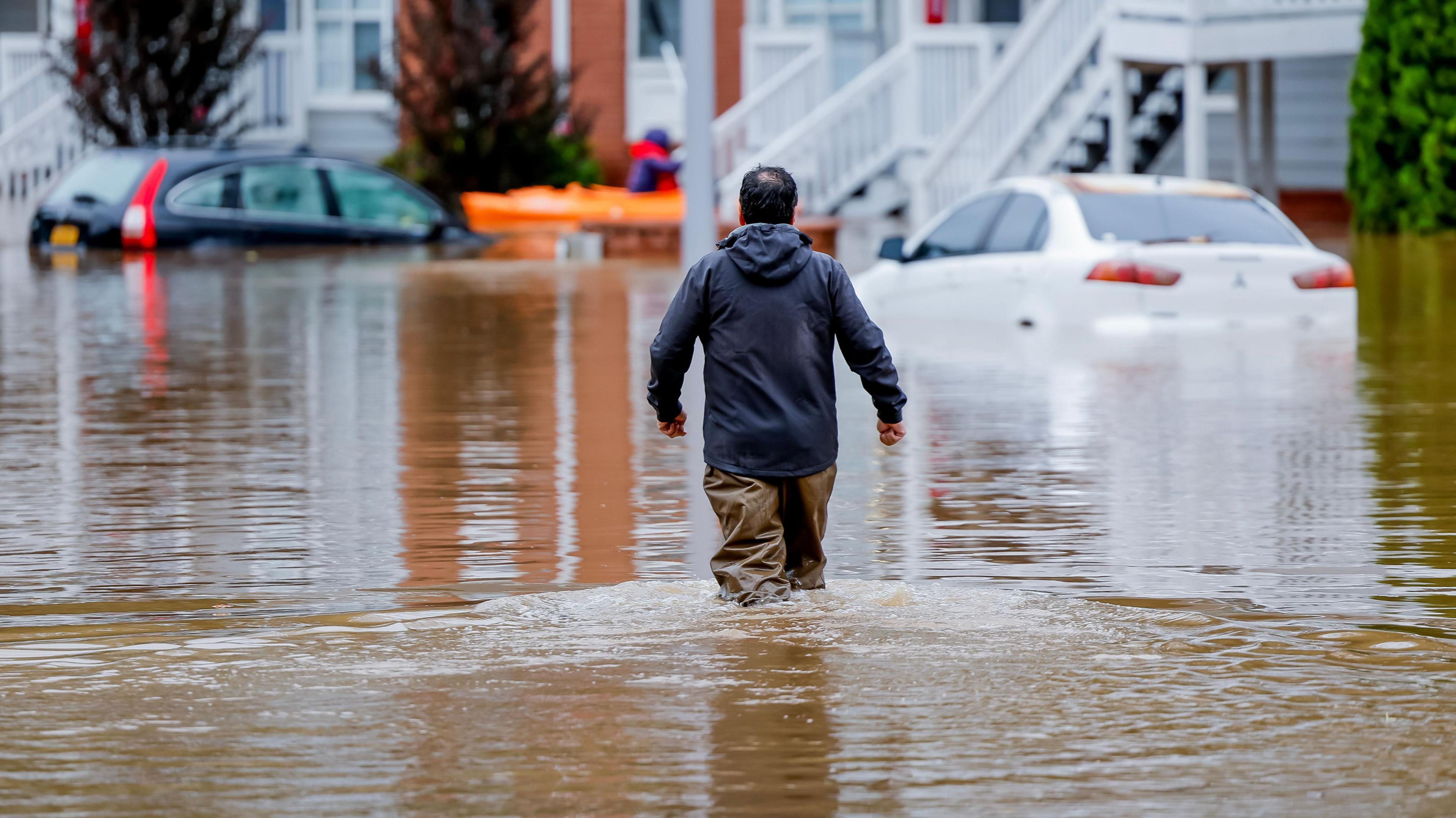 A man wades through a flooded street