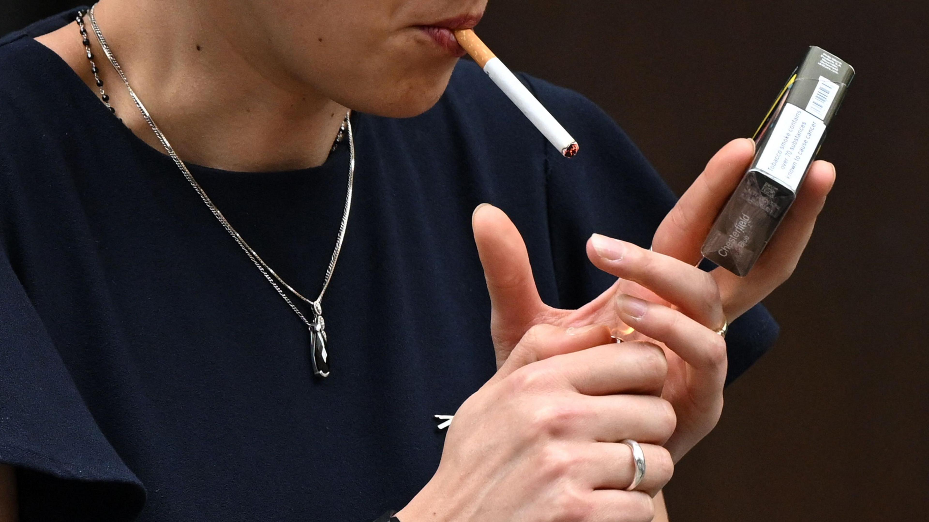 A woman is seen smoking a cigarette in central London.