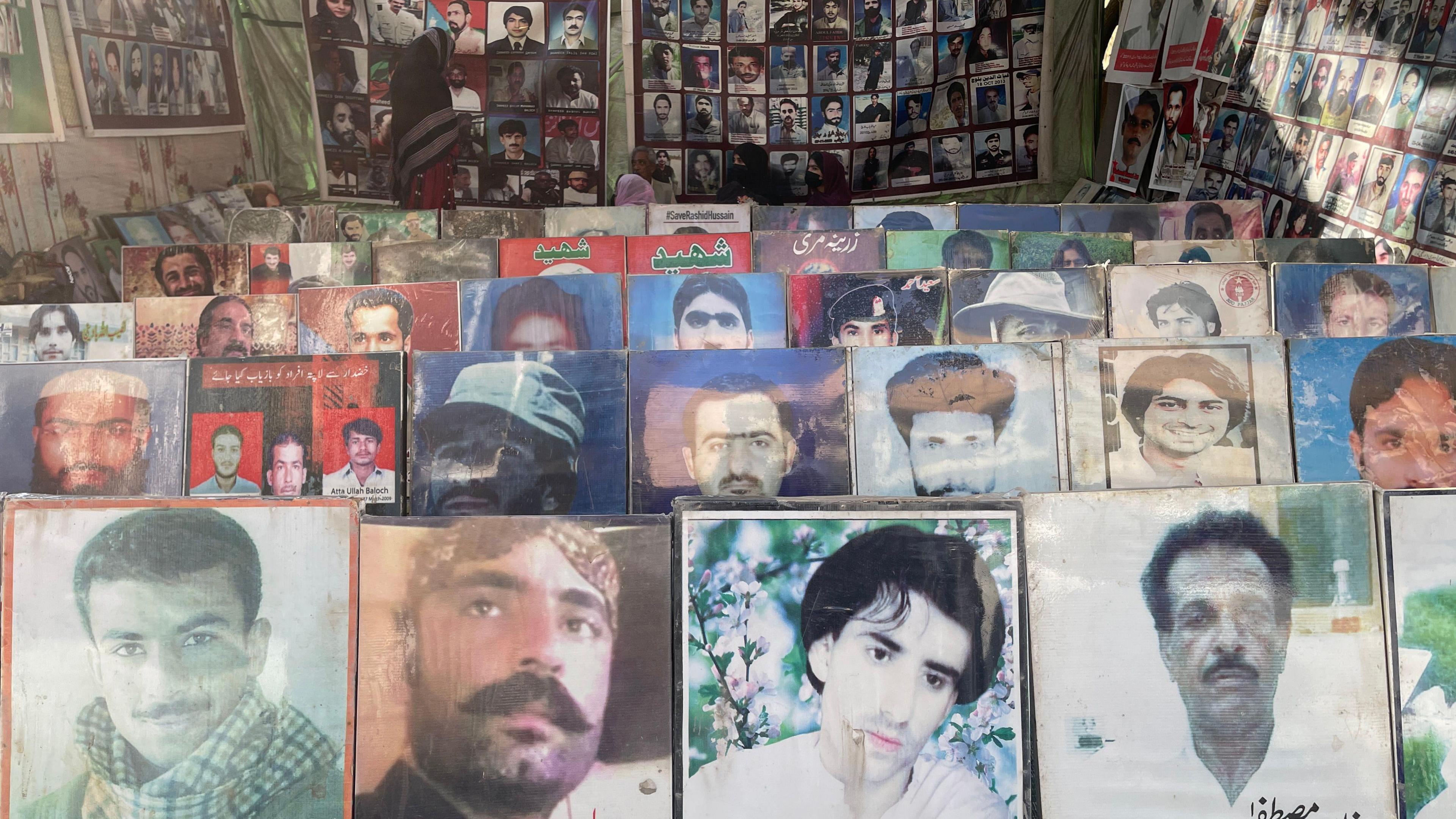 Photographs of missing men are displayed at protests - they appeard to be of all ages, in photos lines up n the ground, and posters hanging at the back.